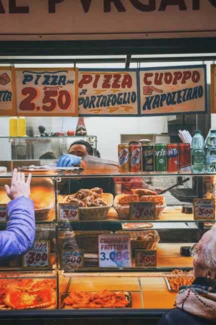 Authentic Italian street food stall in Naples offering pizza and traditional cuoppo fritters.