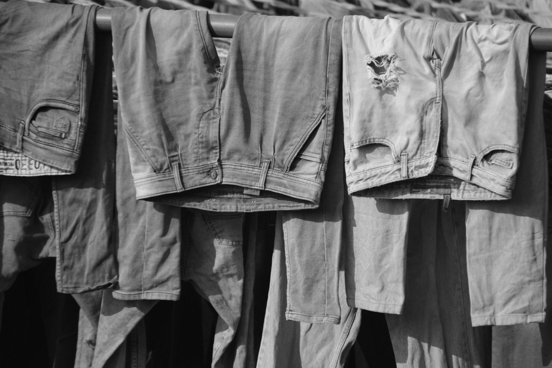 two denim samples side by side showing different fading patterns — one with uniform greyish fade, one with more retained colour