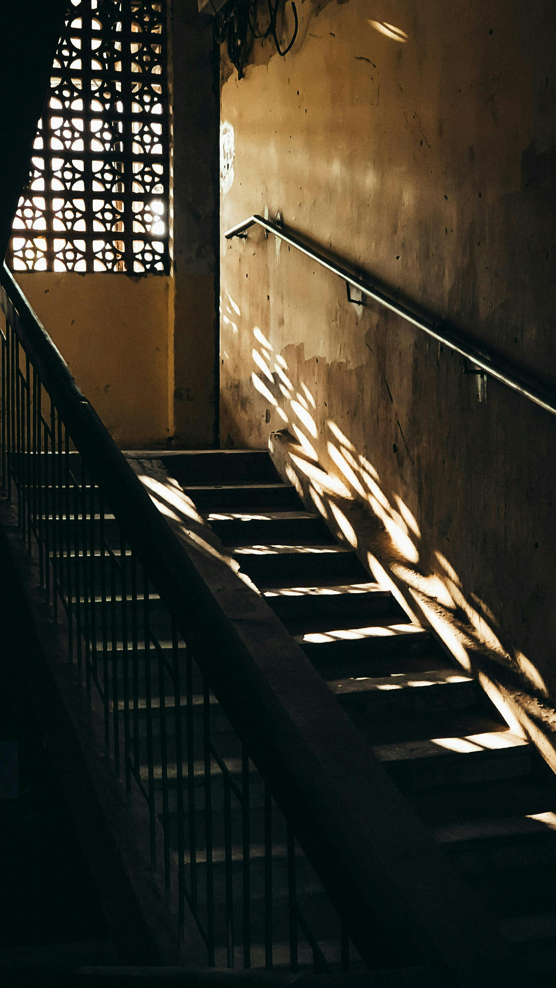 Gratis Escalera interior oscura con dramáticos juegos de luces y sombras en la pared. Foto de stock