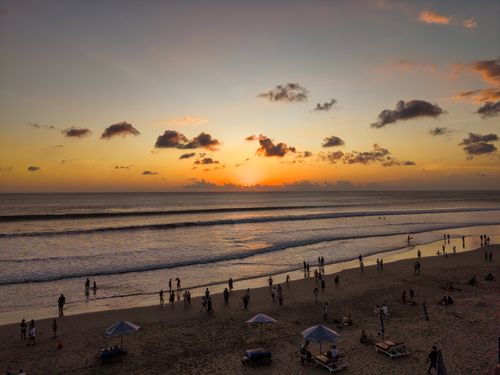 Free Stunning Bali sunset at Kuta Beach with silhouettes of people on the shoreline. Stock Photo