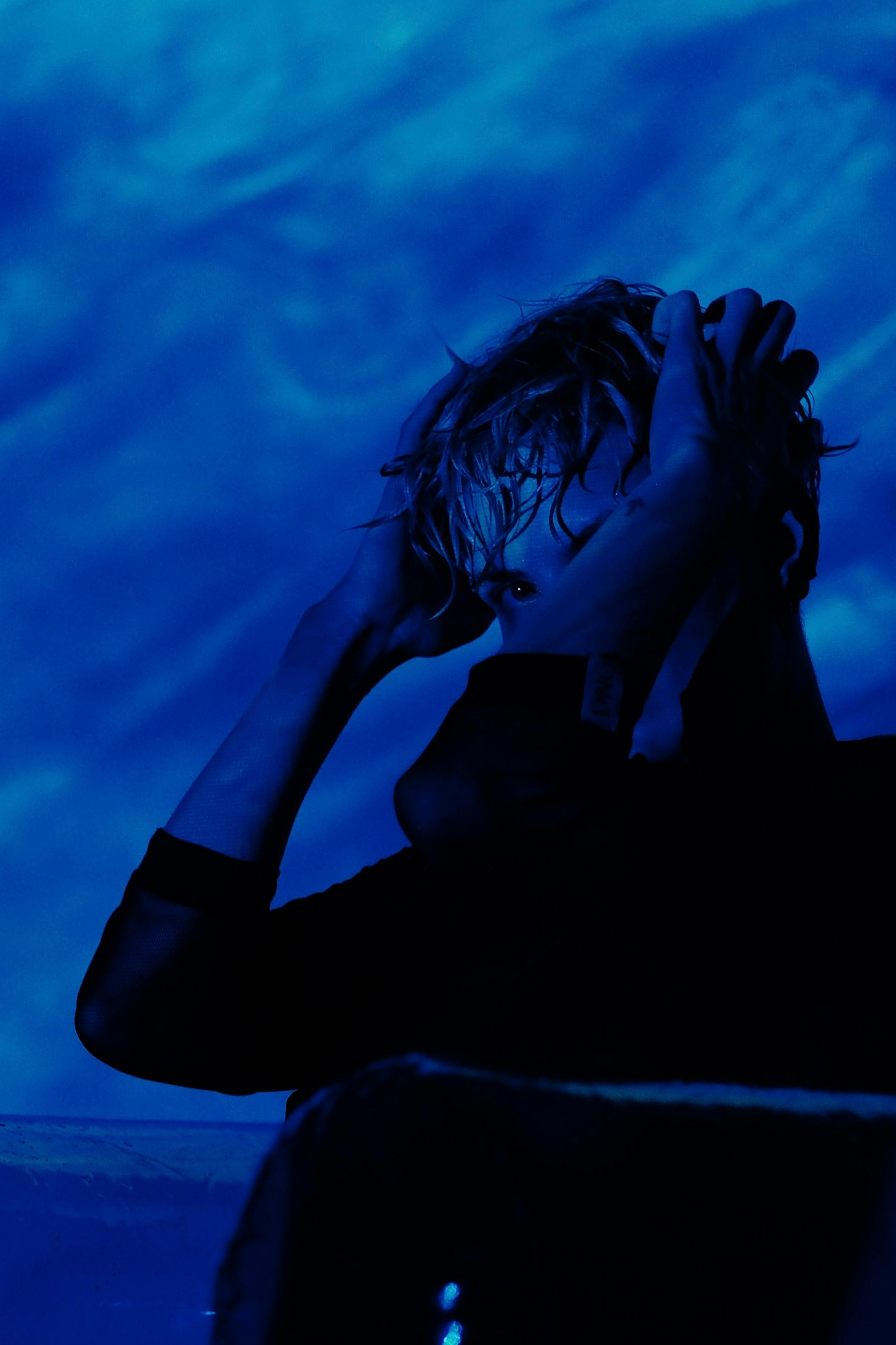 grátis Um retrato artístico criativo capturado com um efeito dramático de iluminação azul. Foto profissional