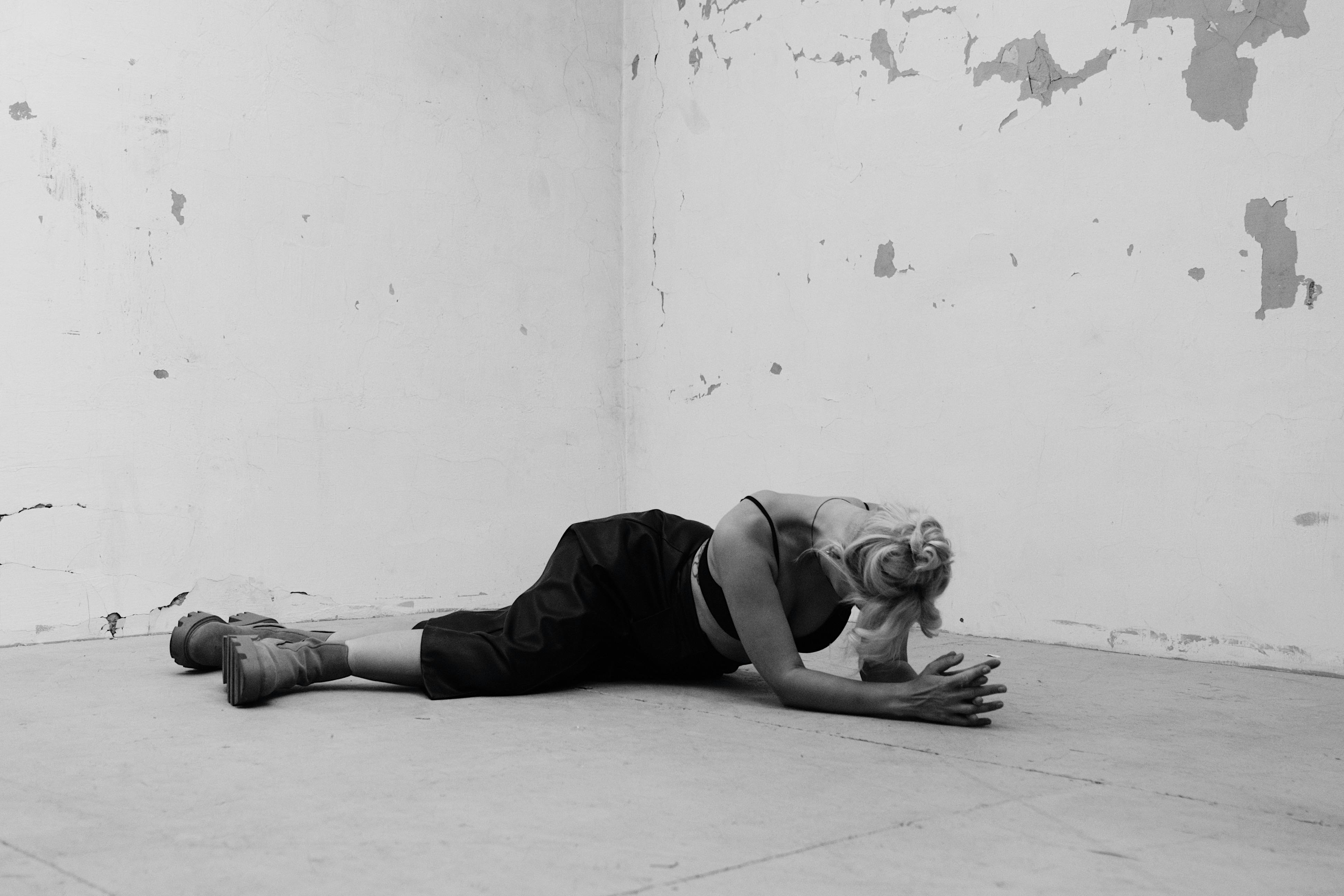 無料 ミニマルな空間の中で、芸術的なポーズをとる女性を捉えた作品。優雅さとコントラストが際立っている。 写真素材