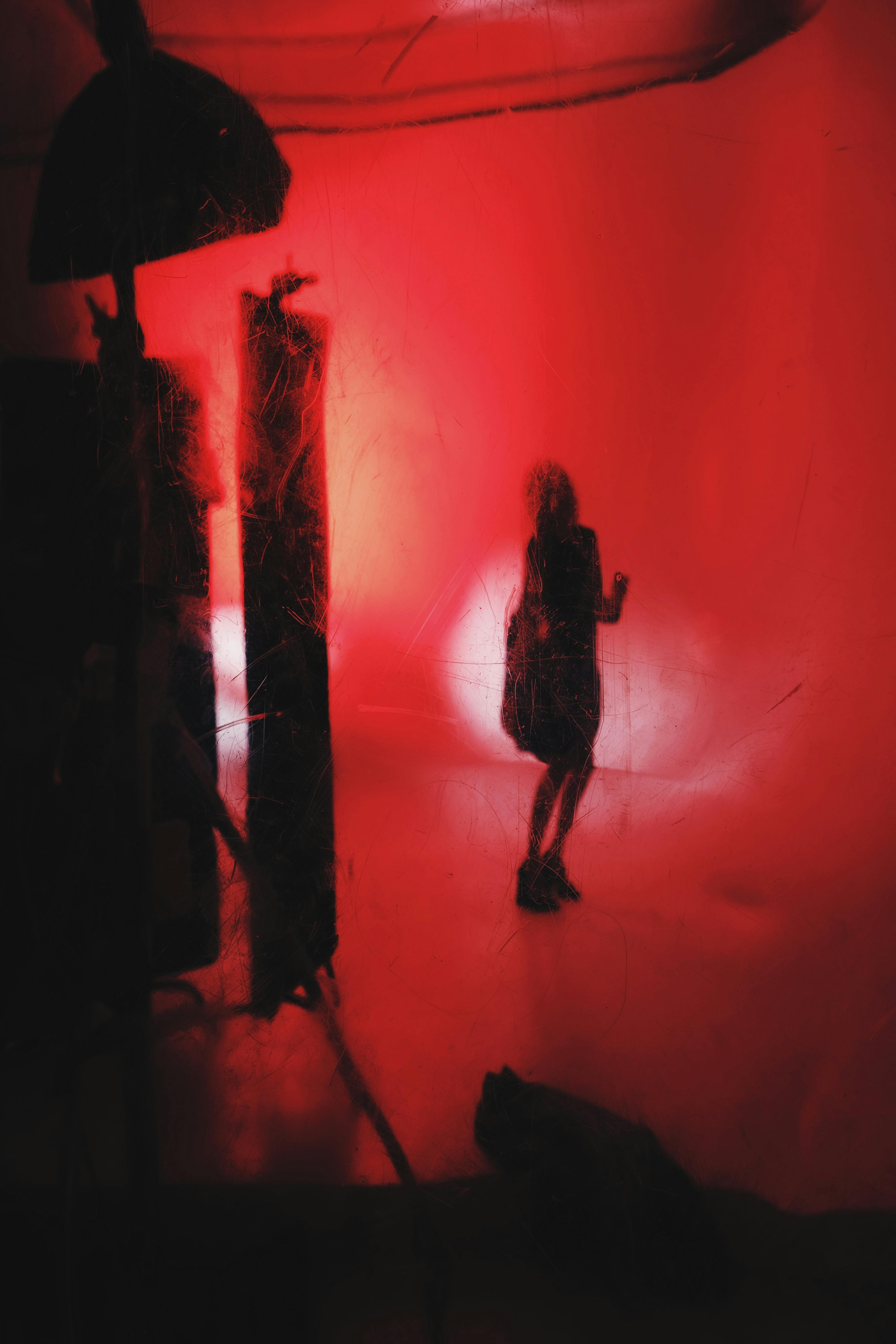 Gratis Imagen abstracta de una silueta en un estudio fotográfico iluminado con luz roja, con efectos dramáticos. Foto de stock