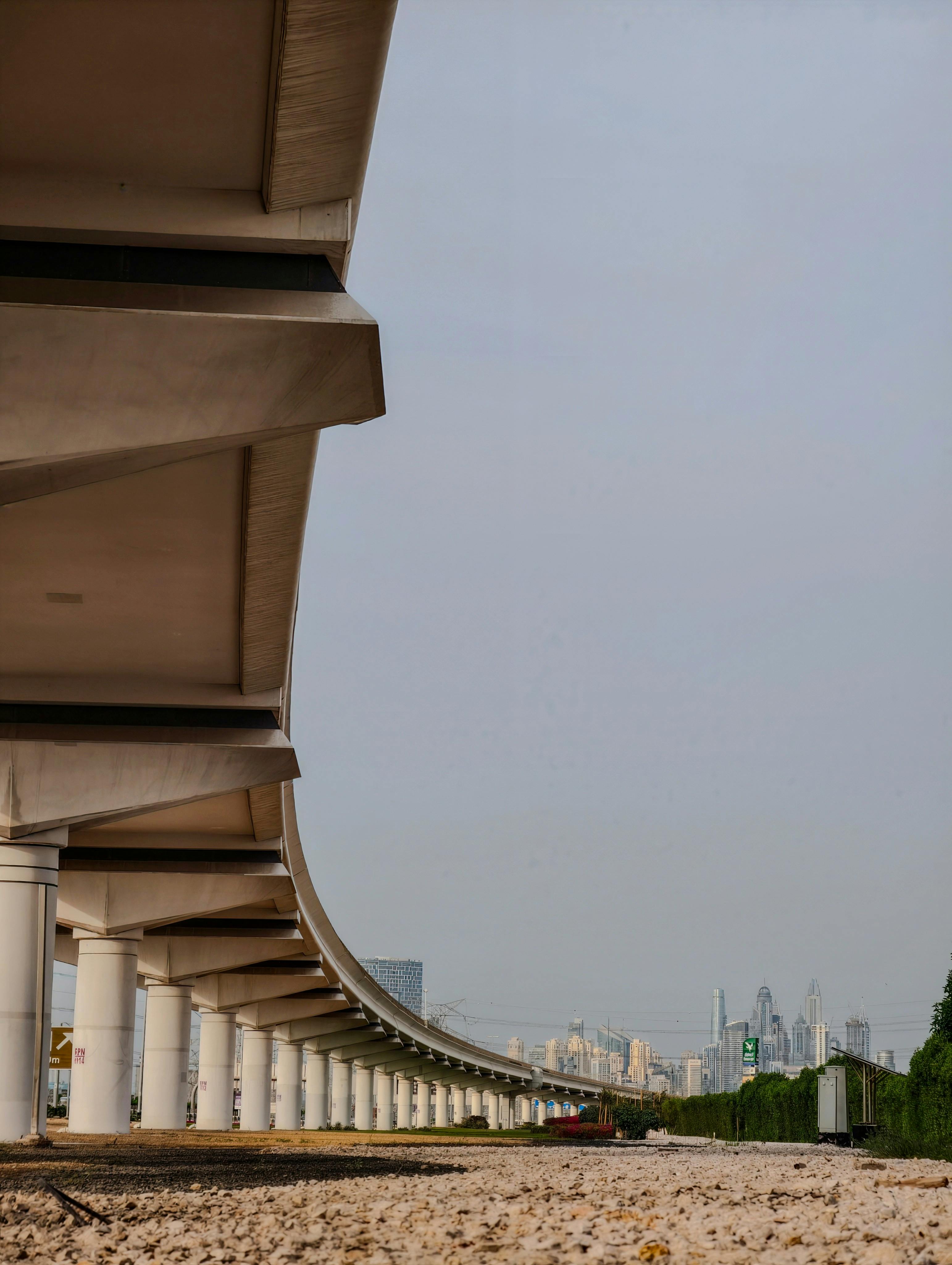 無料 都市景観の上にそびえ立つ近代的な高架橋の壮大な眺め。建築の優雅さを際立たせている。 写真素材