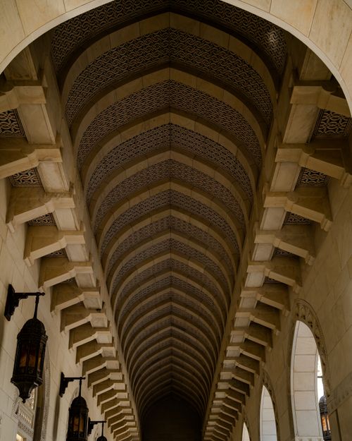 Free Explore the architectural beauty of this ornate arched corridor enhanced by intricate patterns and elegant lighting. Stock Photo
