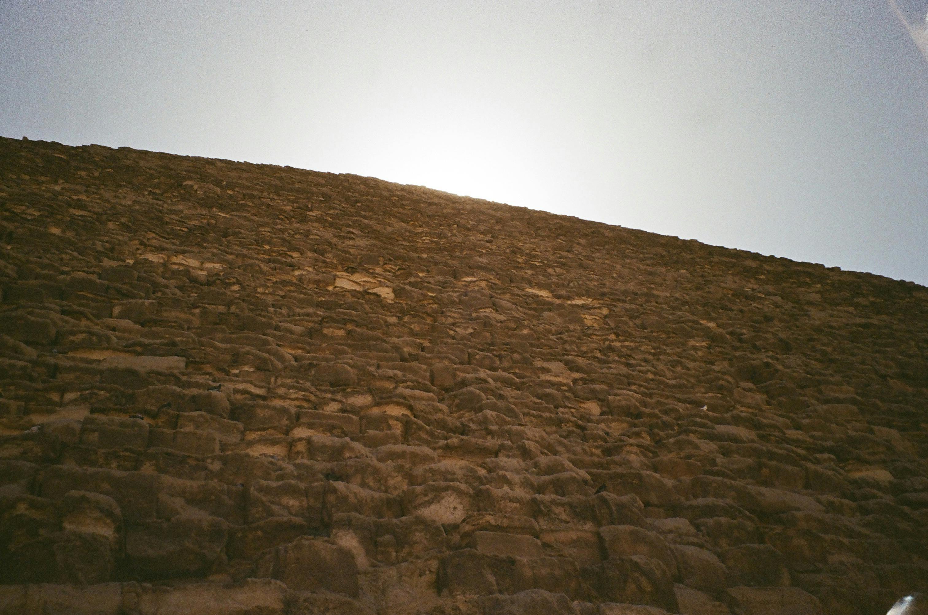 De franc Una perspectiva única de la maçoneria piramidal de Giza amb el sol brillant des de dalt, destacant la textura. Foto d'estoc