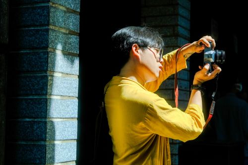 Free A man in Hue, Vietnam takes photos in sunlight, highlighting culture and style. Stock Photo