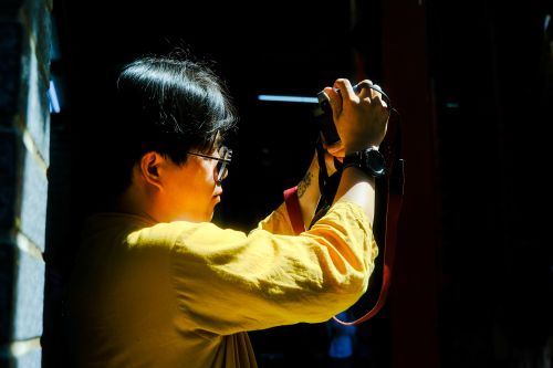 Free Candid shot of a photographer engrossed in work in the vibrant streets of Hue, Vietnam. Stock Photo