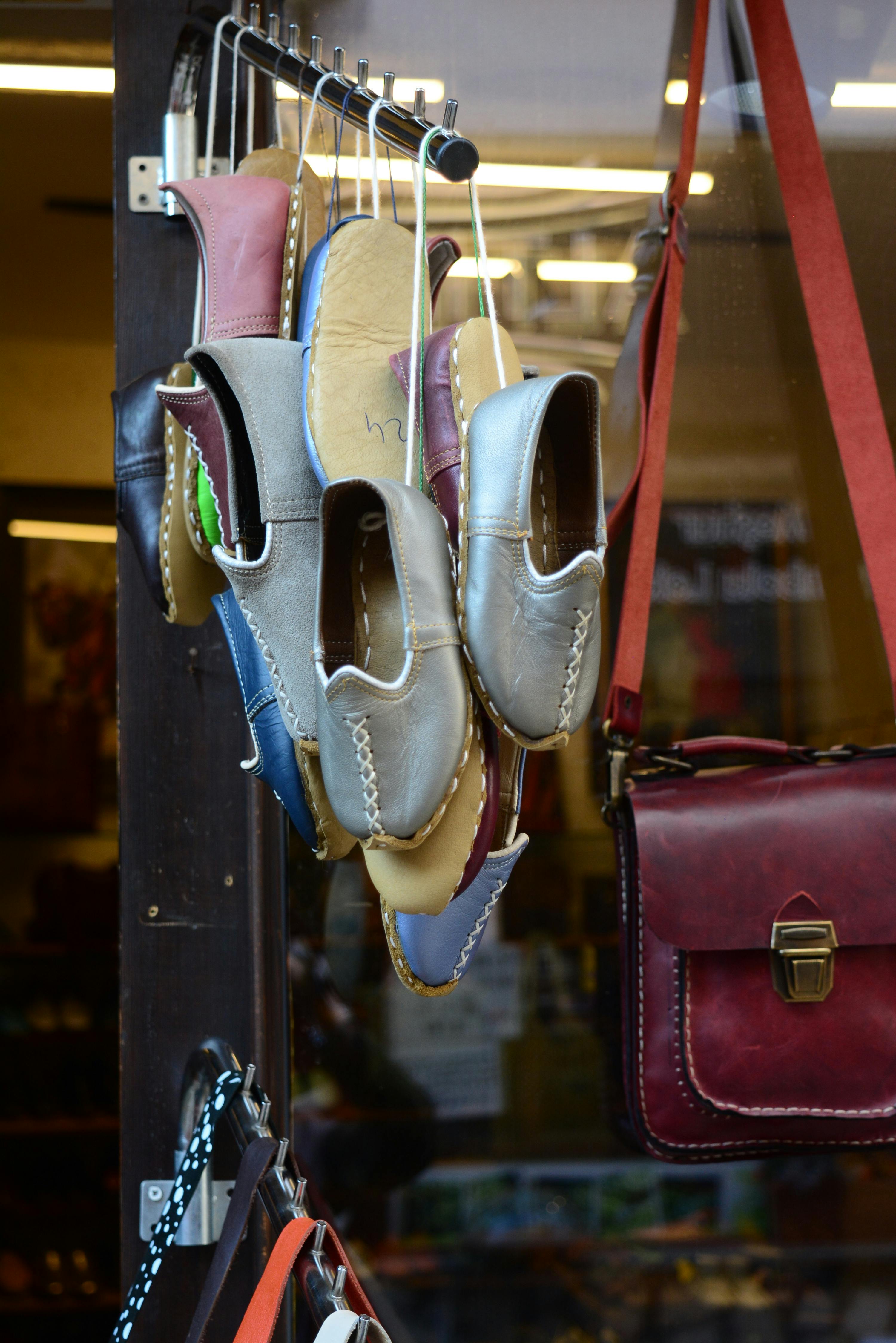 grátis Uma coleção de sapatos de couro tradicionais expostos em um mercado de artesanato, destacando a habilidade artesanal. Foto profissional