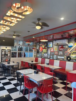 A retro diner interior showcasing vintage decor, red and white seating, and classic ambiance.