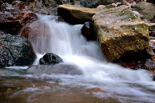 Captivating long exposure of a cascading waterfall over mossy rocks, showcasing nature's tranquility.