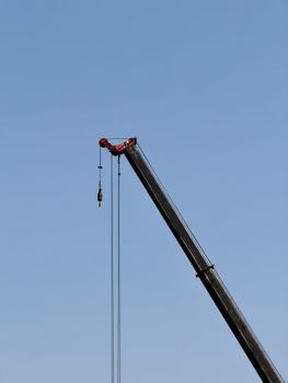A construction crane arm extends against a clear blue sky in Shanghai, symbolizing development and progress.