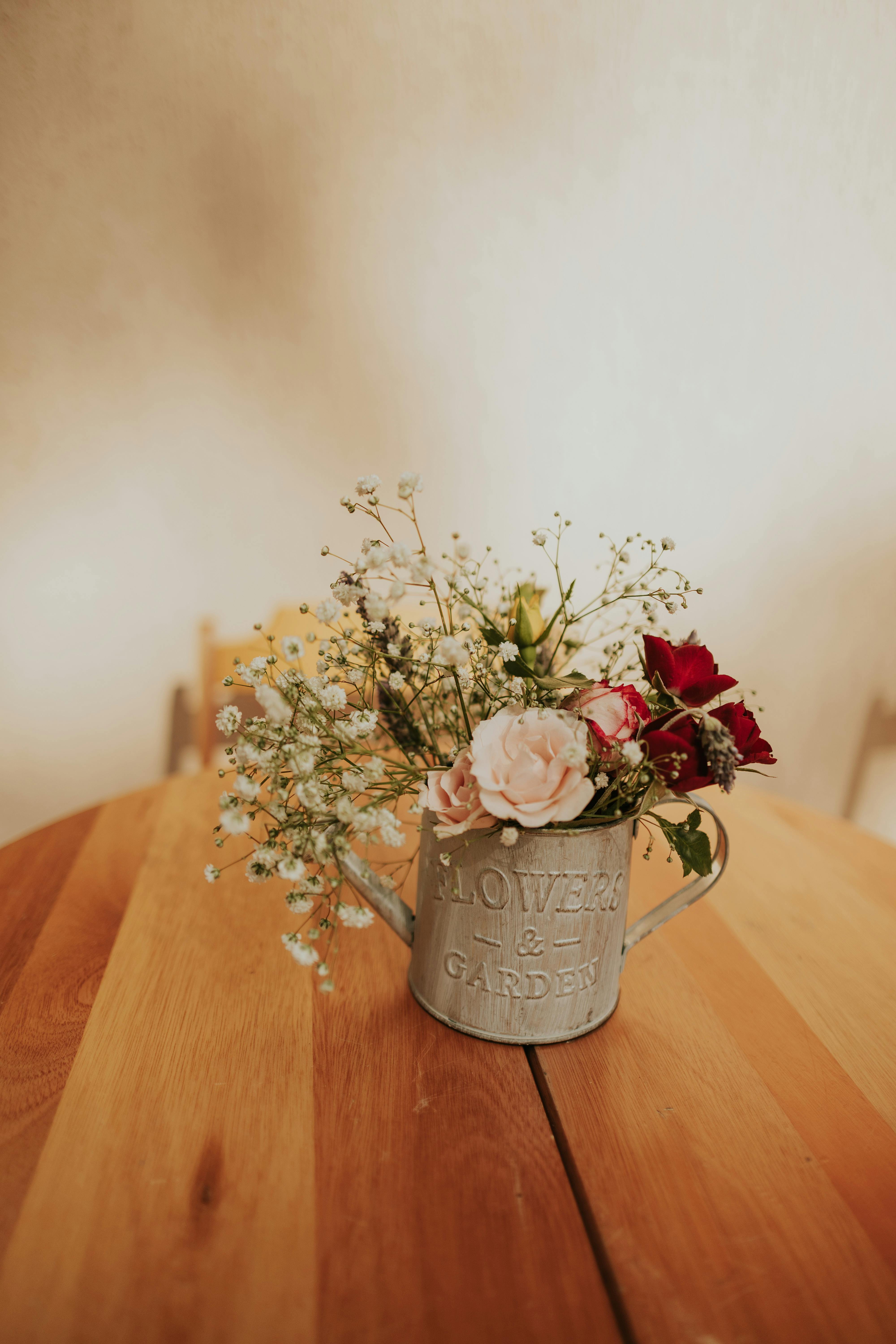 Gratuit Aranjament floral de interior confortabil, într-un ghiveci metalic vintage, pe o masă de lemn, evocând o atmosferă caldă și naturală. Fotografie de stoc