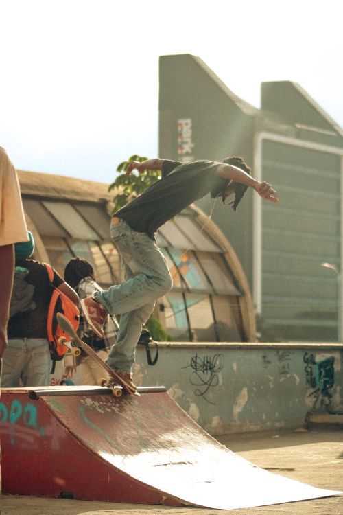 Free A skateboarder mid-trick on a ramp in a vibrant urban skate park setting. Stock Photo