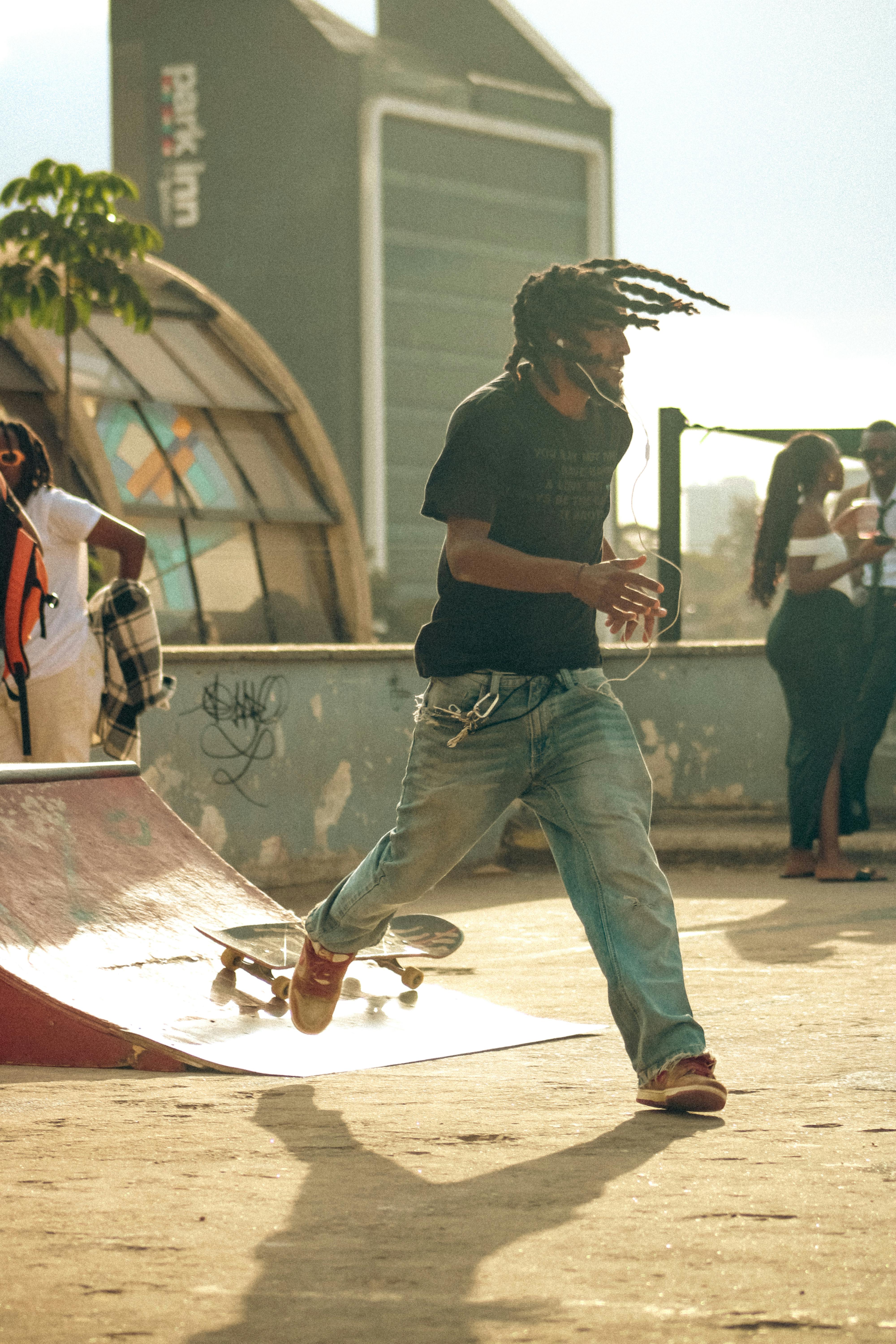 Gratis Dynamisk gatescene med skateboarding i urbane omgivelser med en moderne bybakteppe. Arkivbilde