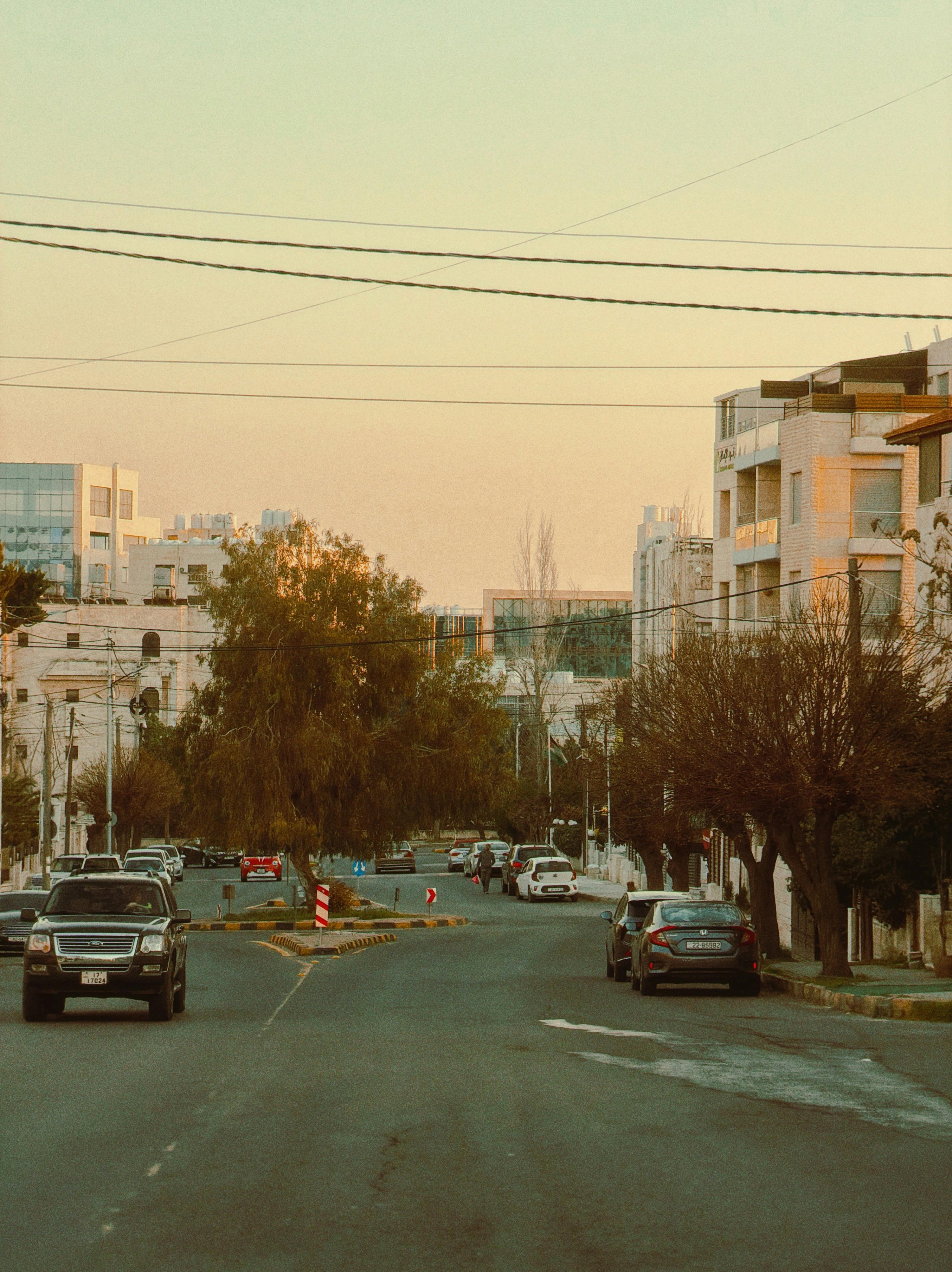 Gratuit O stradă senină din Amman, Iordania, surprinsă la apus, cu o atmosferă caldă de primăvară, care ilustrează viața urbană. Fotografie de stoc