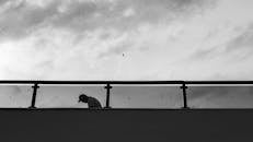 Silhouette of Person on a Bridge at Twilight