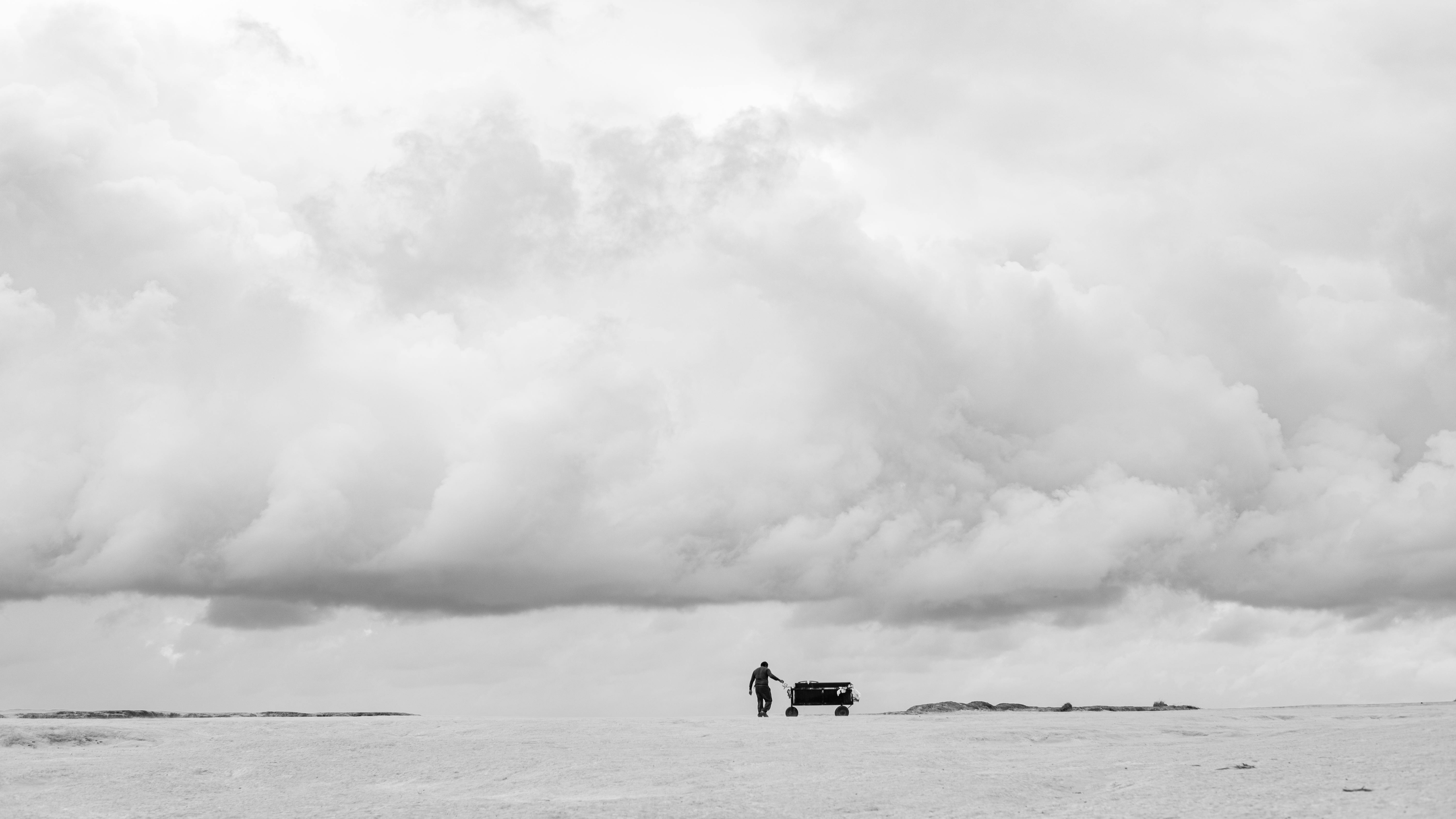 Gratuit Un călător singuratic se plimbă printr-un deșert întins sub un cer înnorat dramatic în Natal, Brazilia. Fotografie de stoc