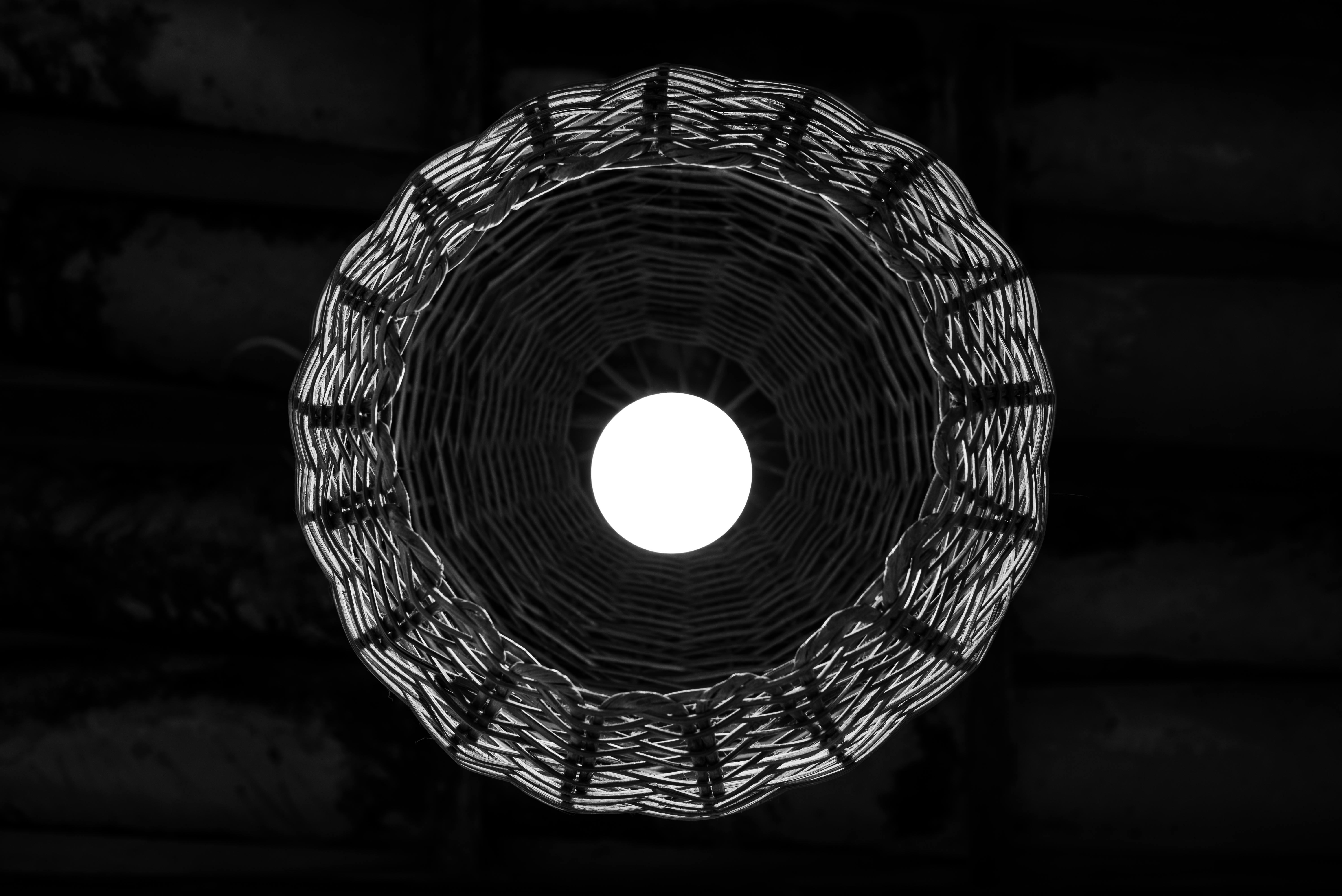 Gratis Una suggestiva vista dall'alto di una lampada a forma di cesto intrecciato, con un'illuminazione scenografica che crea un motivo circolare. Foto a disposizione