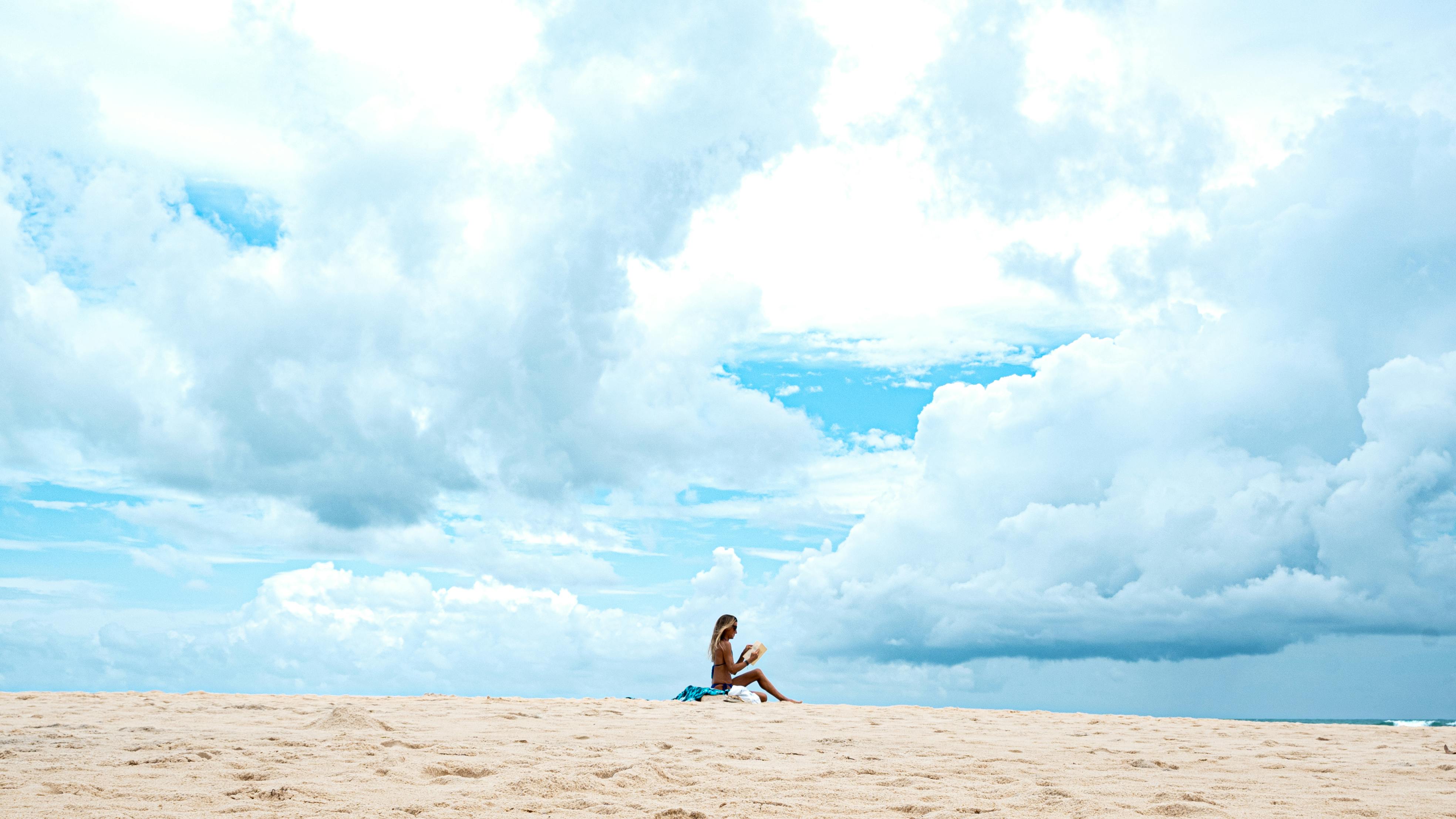 Ücretsiz Brezilya'nın Natal kentindeki kumlu bir plajda, etkileyici bulutların altında bir kadın huzurlu bir anın tadını çıkarıyor. Stok Fotoğraflar