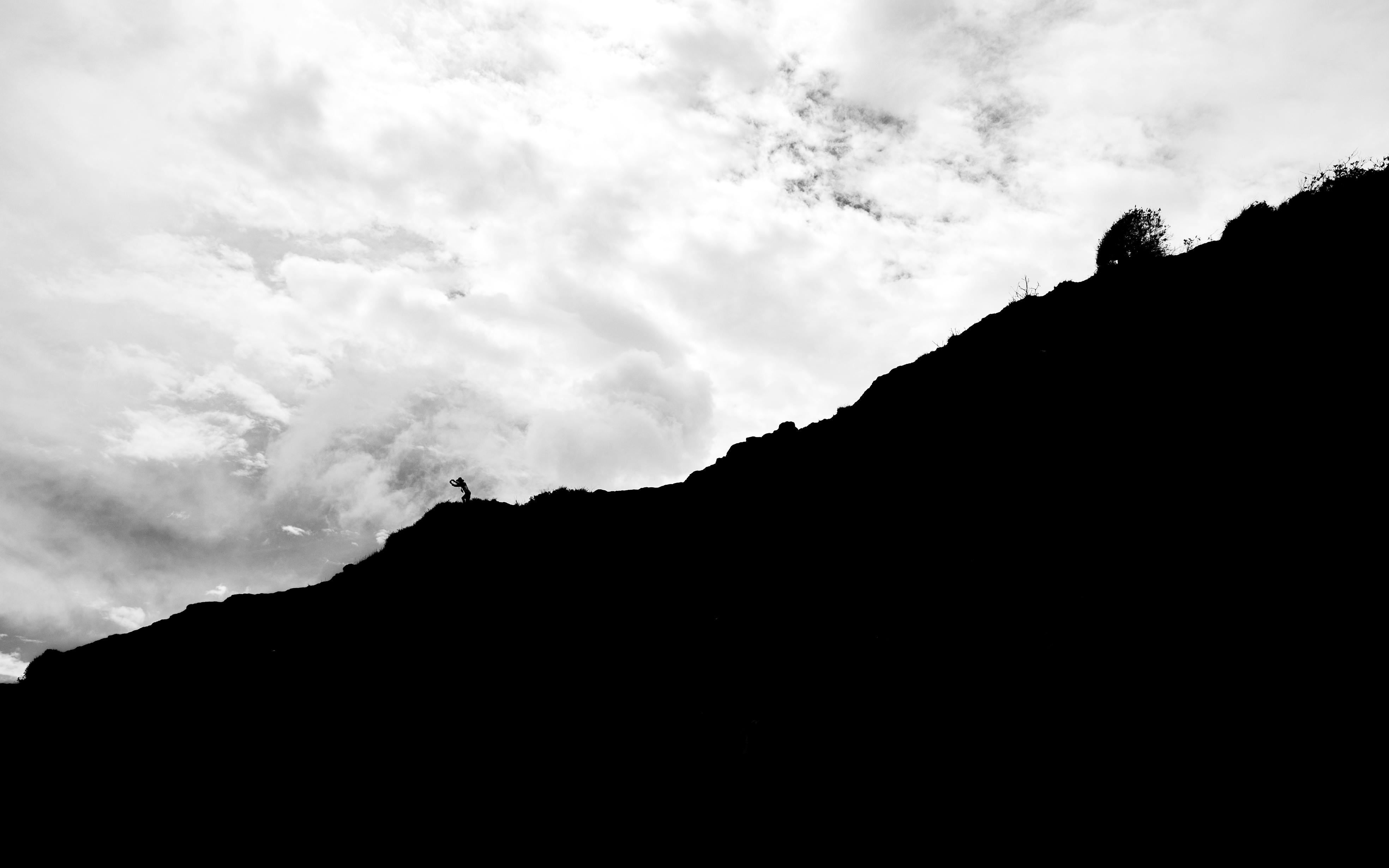 Gratis Silhuet af vandrer på en stejl klippe med dramatisk overskyet himmel i Natal, Brasilien. Lagerfoto