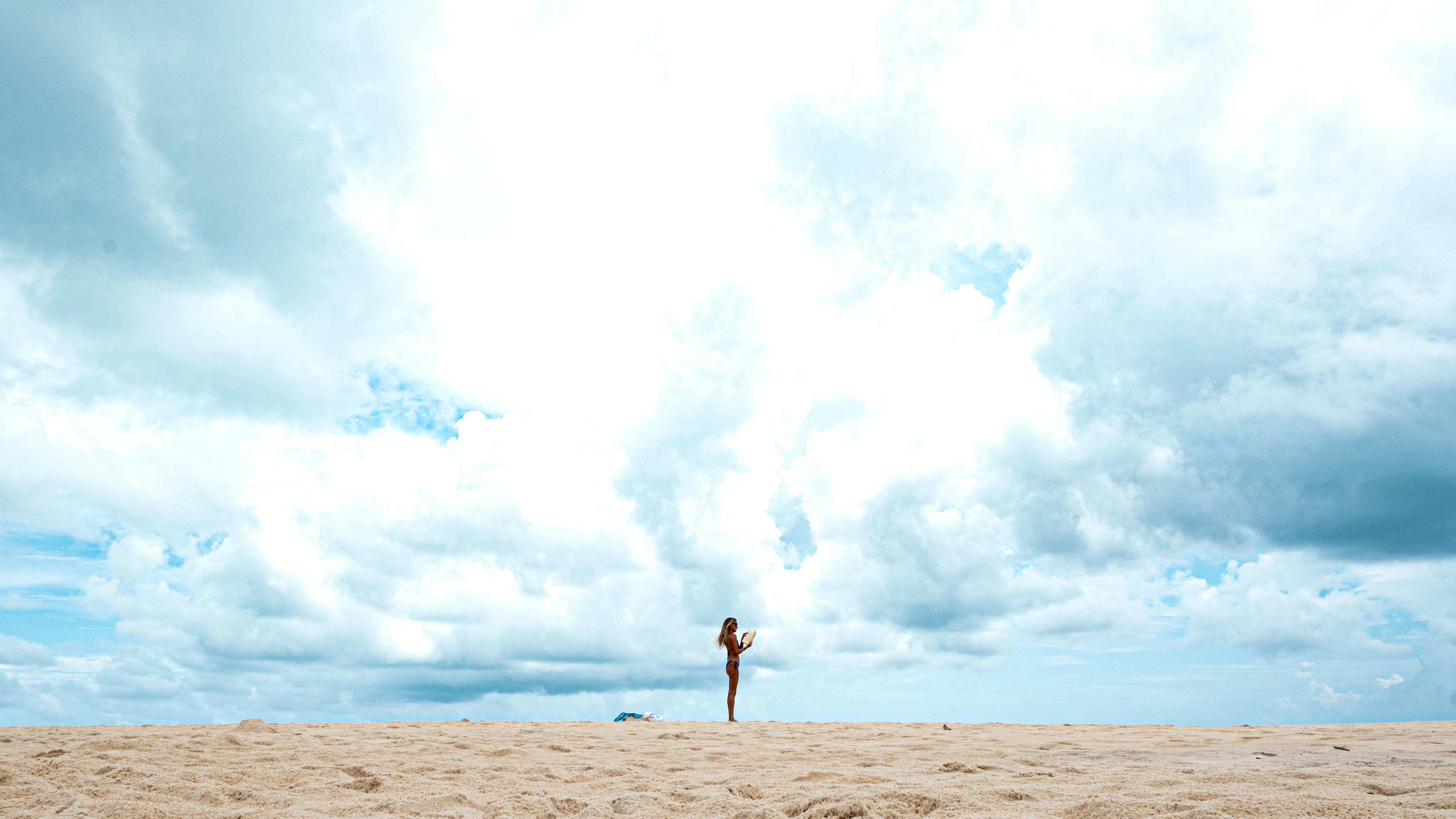 Δωρεάν Γυναίκα κάνει γιόγκα μόνη της σε μια αμμώδη παραλία κάτω από έναν απέραντο, συννεφιασμένο ουρανό στο Νατάλ της Βραζιλίας. Φωτογραφία από στοκ φωτογραφιών