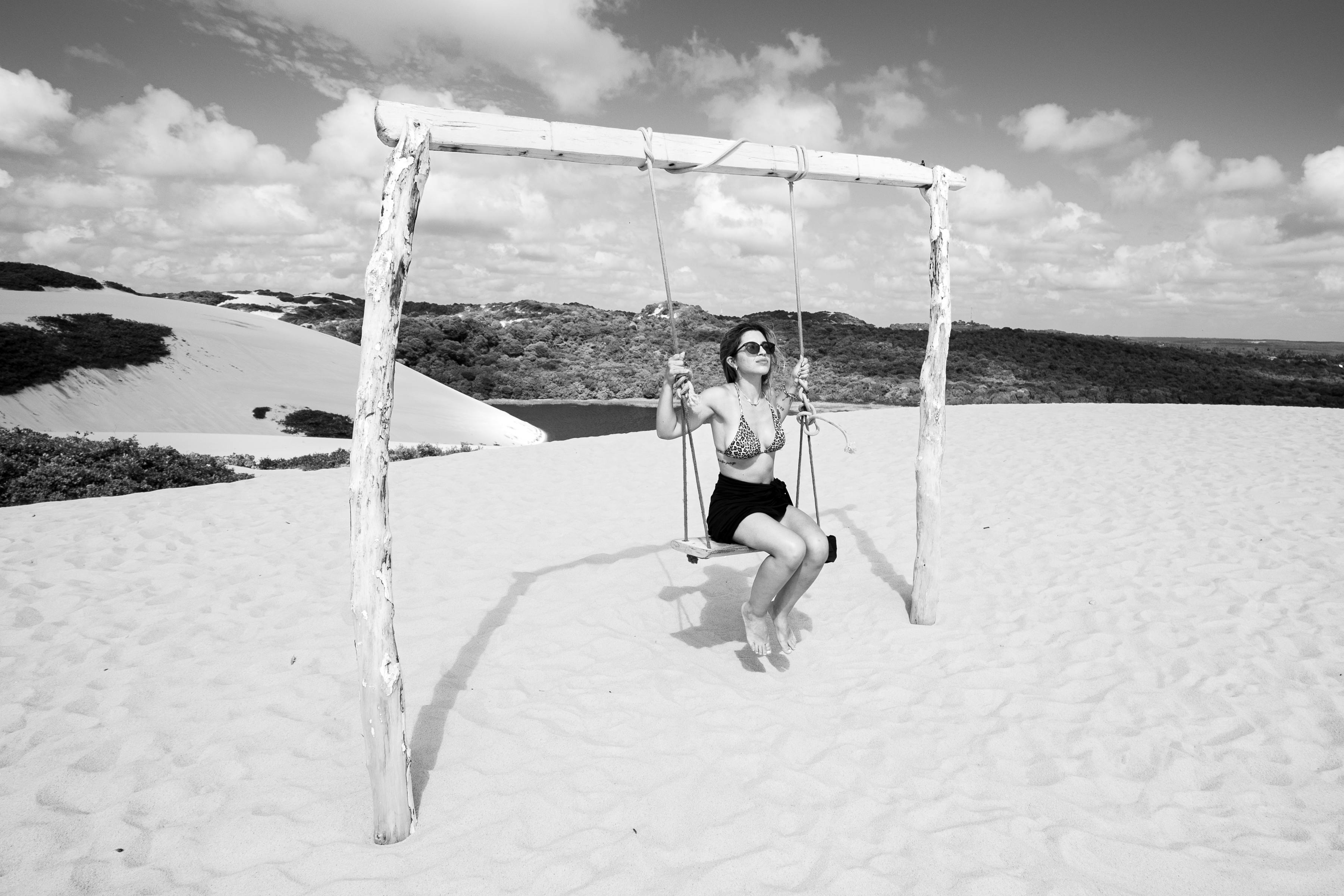 無料 ブラジルのナタールにある砂丘で、晴れた空の下、女性がブランコ​​を楽しんでいる。 写真素材