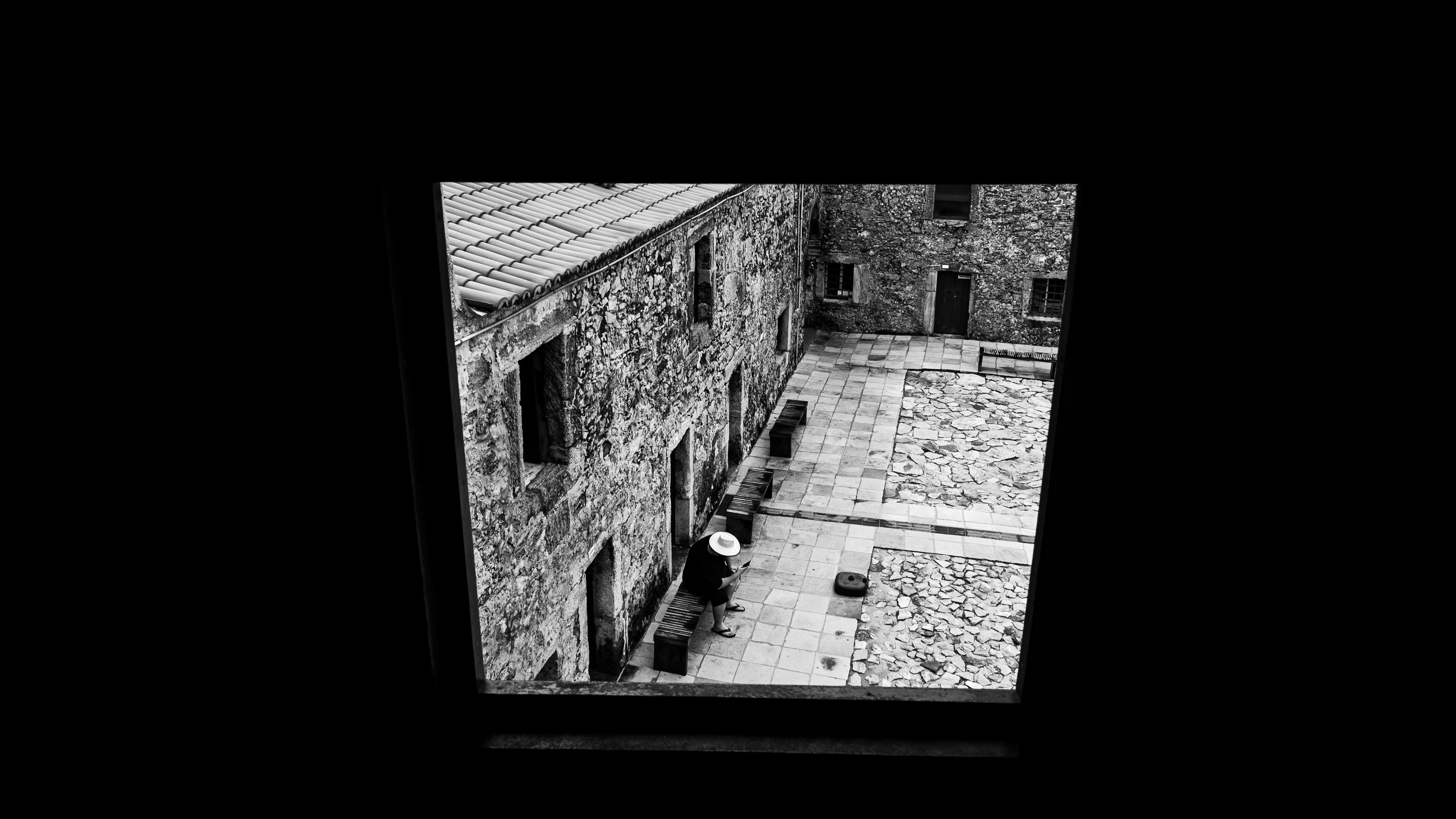 Ücretsiz Pencereden görünen tarihi taş avlunun siyah beyaz görüntüsü. Stok Fotoğraflar