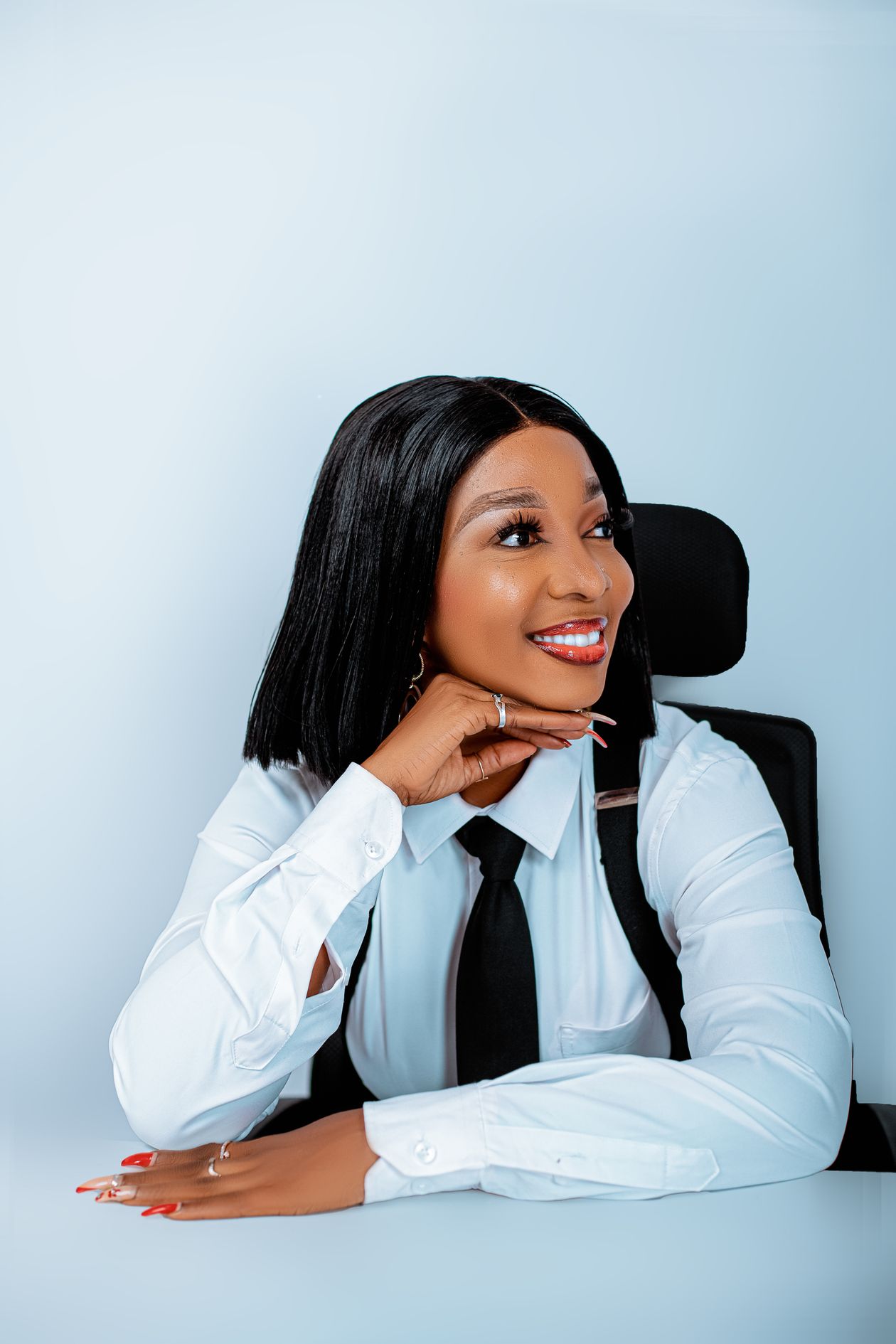 A confident African woman freelancer smiling, resting her chin on her hand