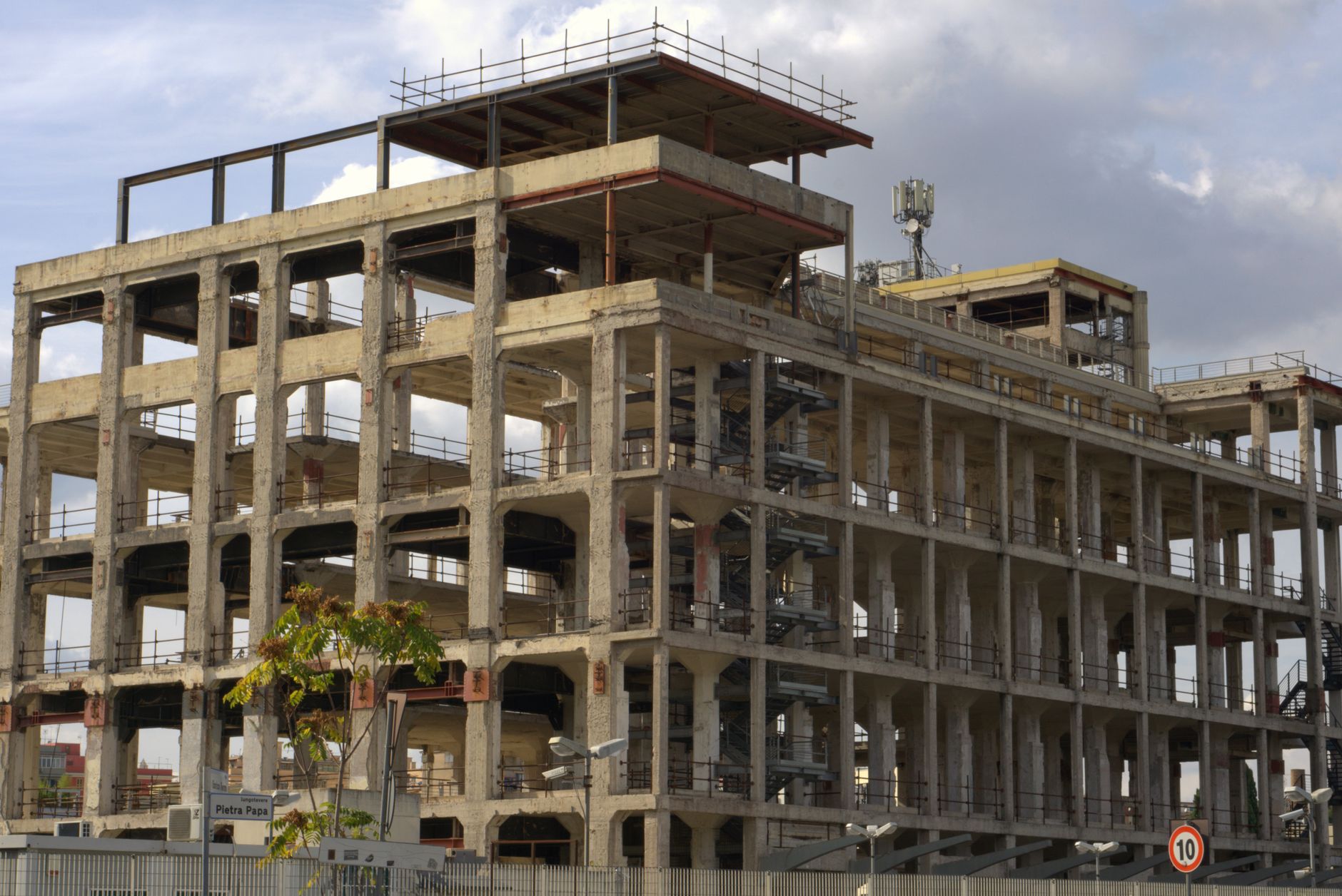 A partially constructed and abandoned building in Rome, Italy, showing its skeletal frame.