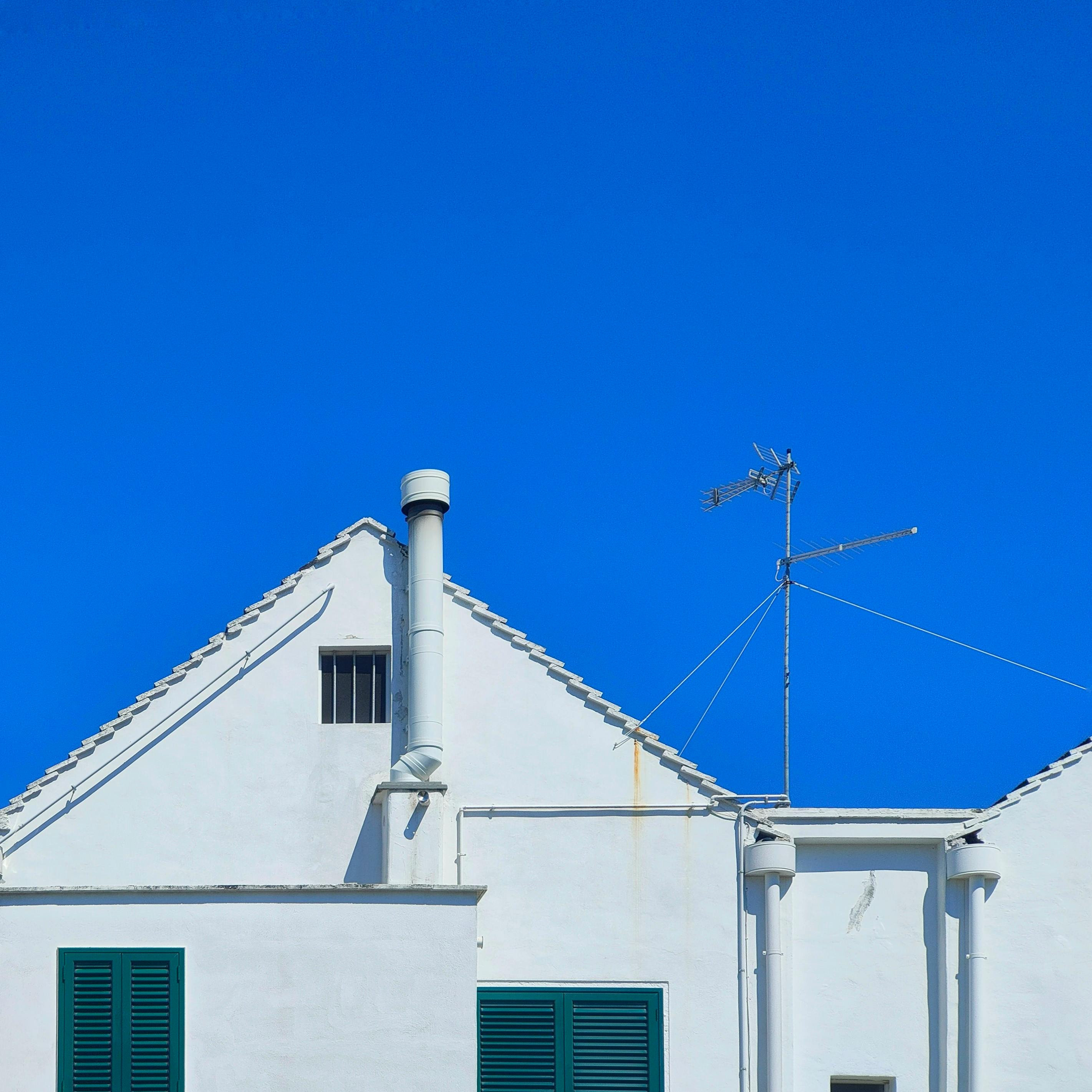 bezplatná Tradiční bílý dům v italské Apulii na pozadí zářivě modré oblohy. Jasně viditelné architektonické detaily. Základová fotografie
