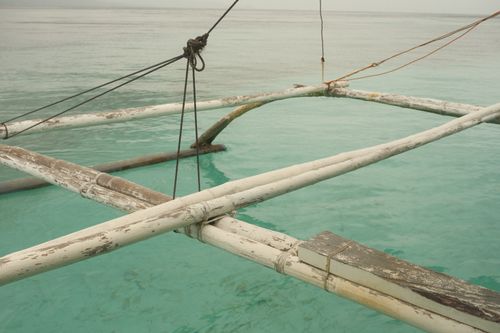 Free A traditional outrigger floats on clear turquoise waters in Central Visayas, Philippines. Stock Photo