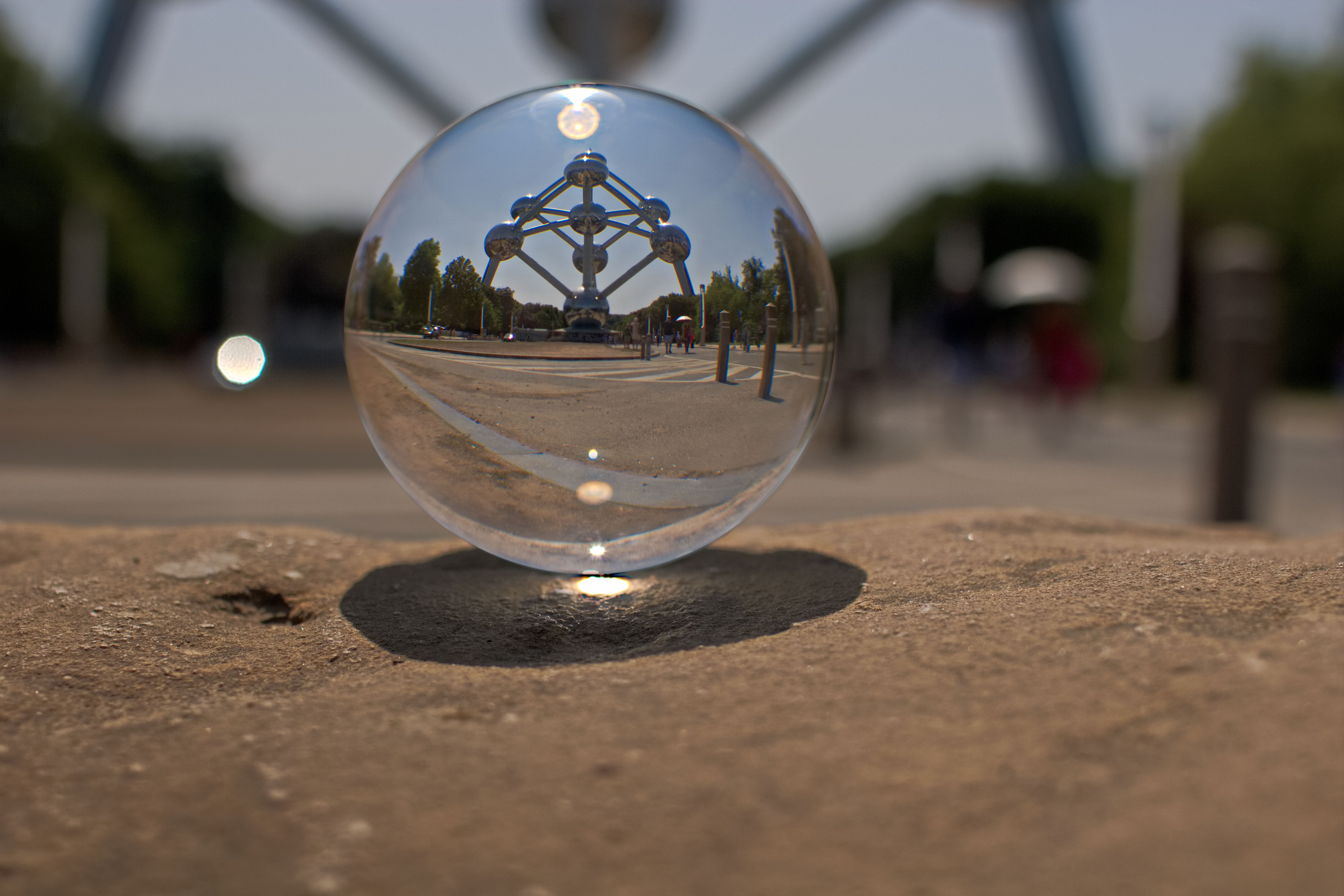Crystal ball reflects the iconic Atomium structure in Belgium on a sunny day.
