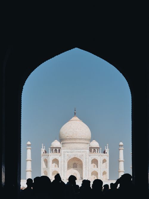 Free Silhouette of people framing a stunning view of the Taj Mahal under a clear sky. Stock Photo