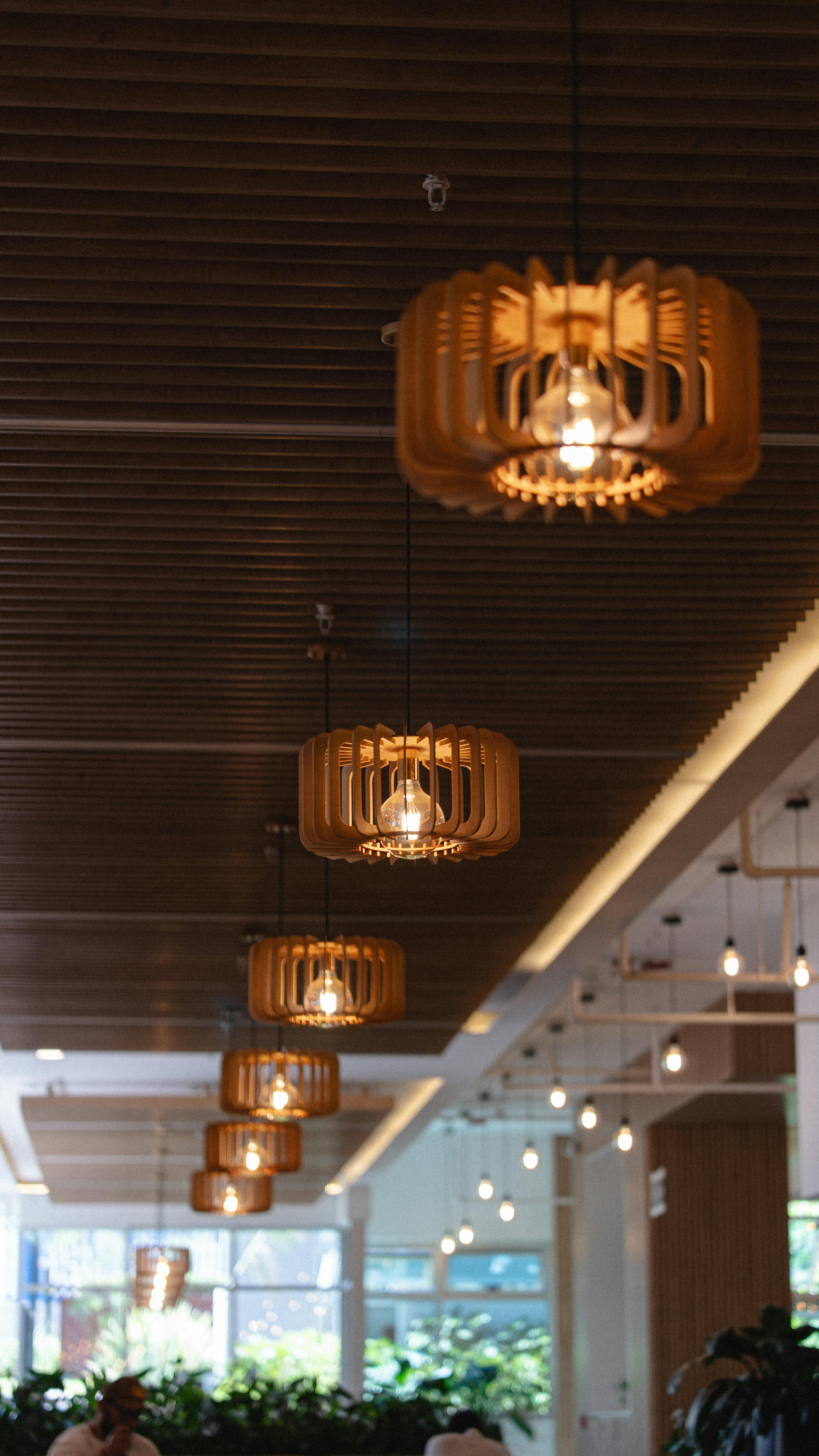 免费 优雅的室内环境，温暖的灯光下点缀着现代木质吊灯。 素材图片