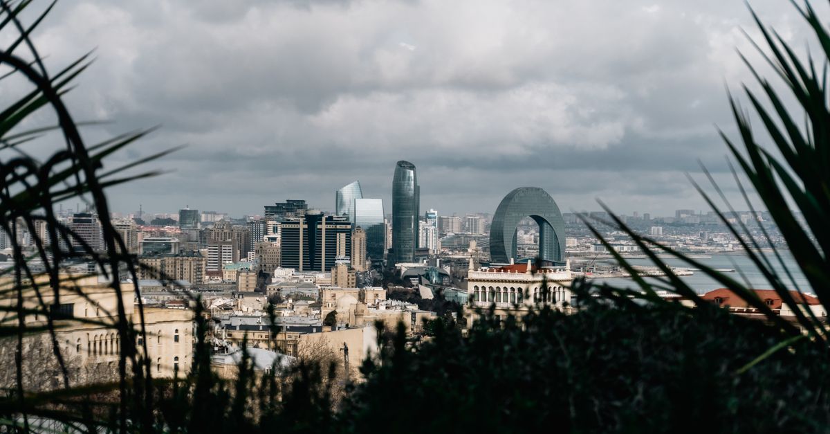Scenic view of Baku's skyline with modern architecture under cloudy sky.