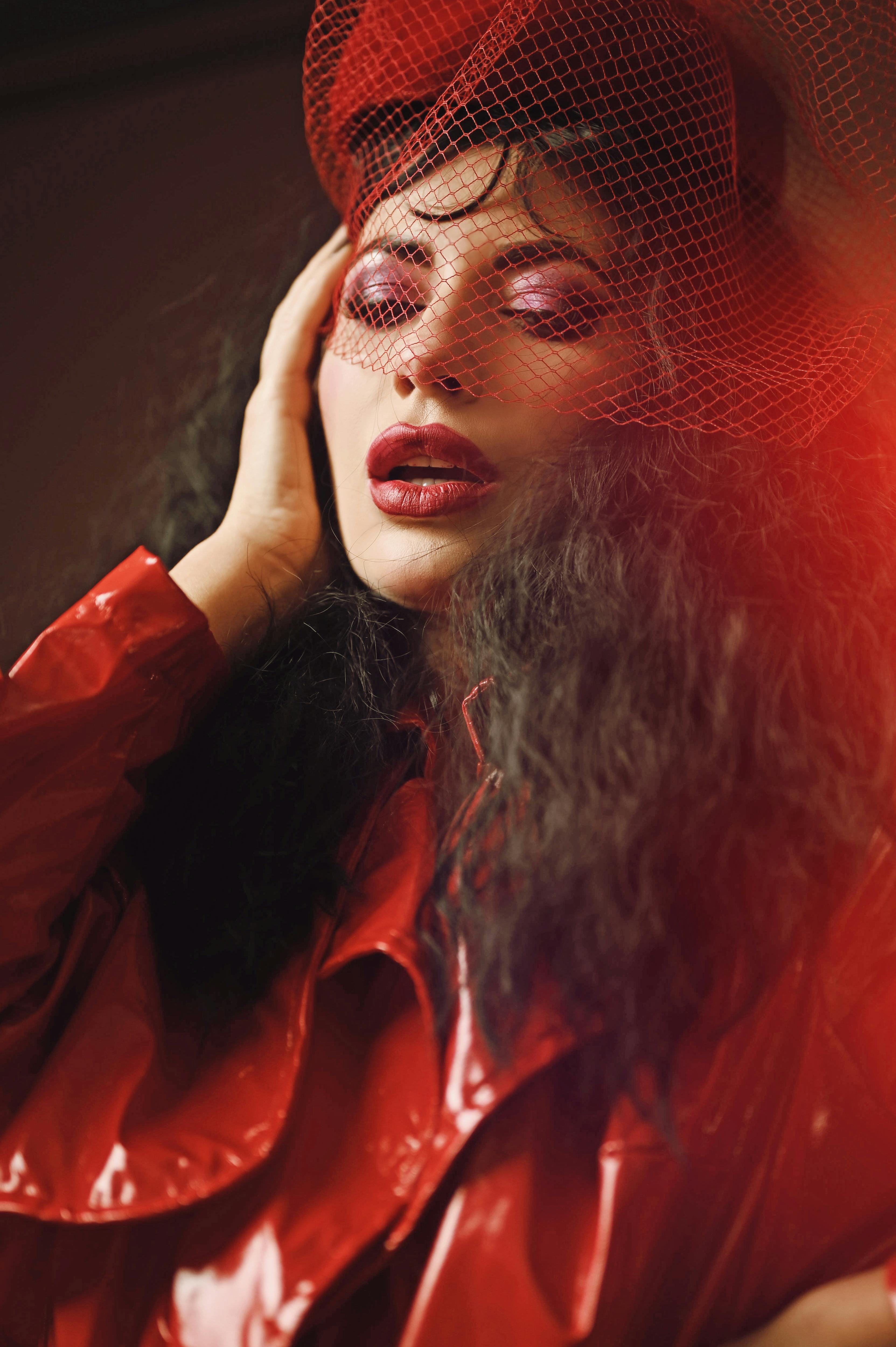 Miễn phí Bức chân dung đầy phong cách của một người phụ nữ trong bộ trang phục màu đỏ nổi bật và mạng che mặt, toát lên vẻ quyến rũ. Ảnh lưu trữ