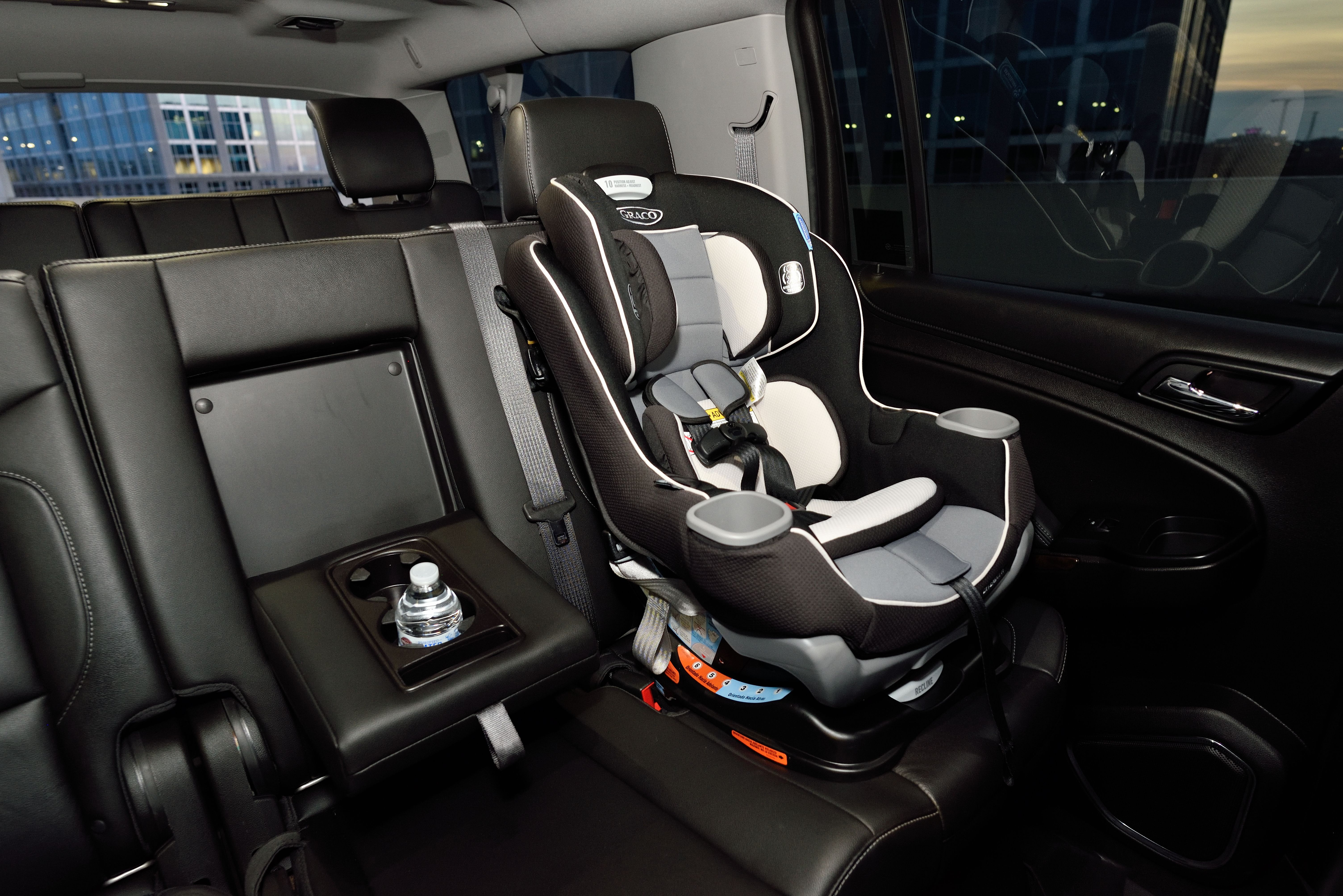 Child car seat secured on the rear passenger seat of a black vehicle