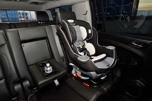 Safety car seat securely installed in the back of a modern vehicle. Ideal for family travel.