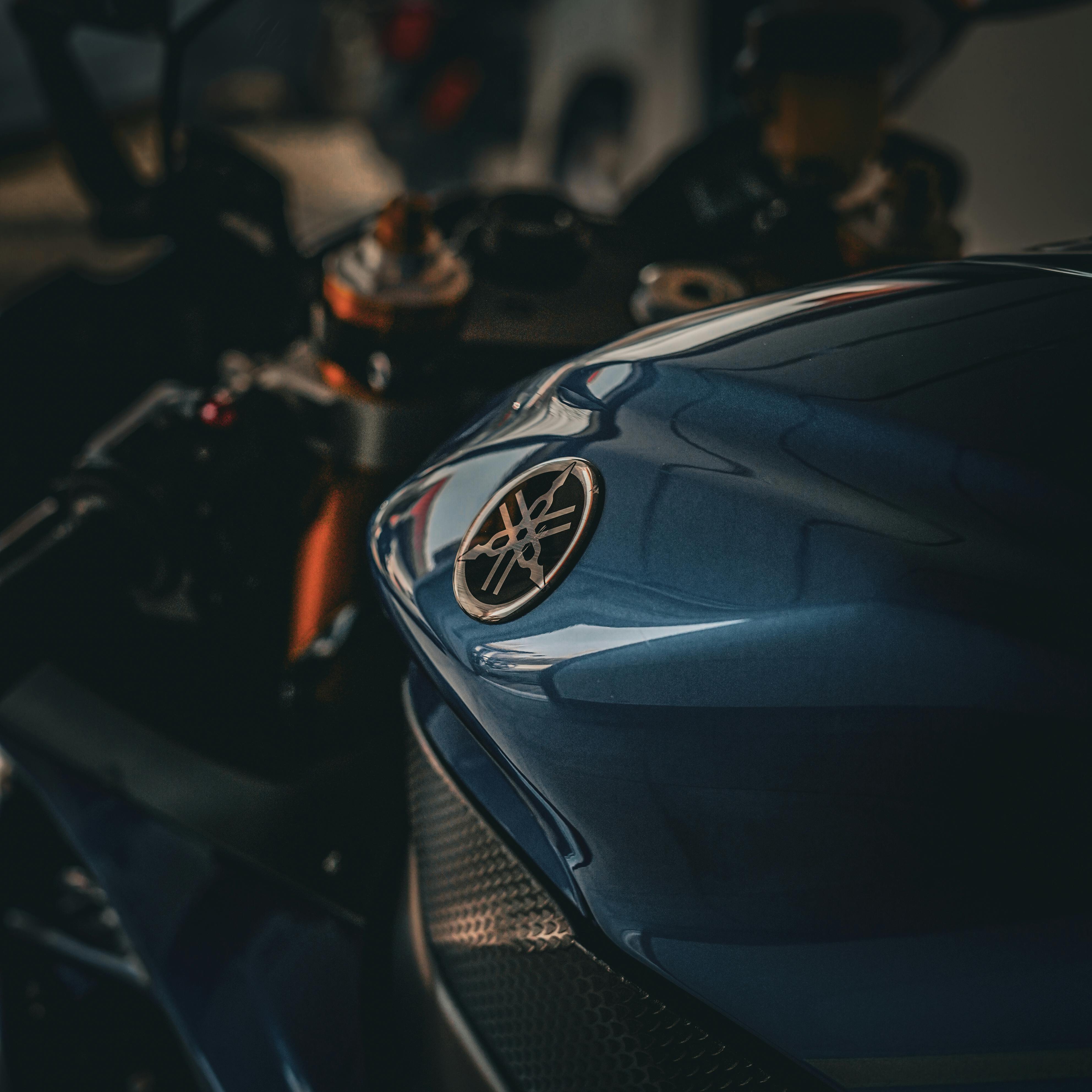 Ücretsiz Parlak amblemi olan mavi bir motosiklet deposunun detaylı görünümü, şık tasarımı ve dokusunu vurguluyor. Stok Fotoğraflar