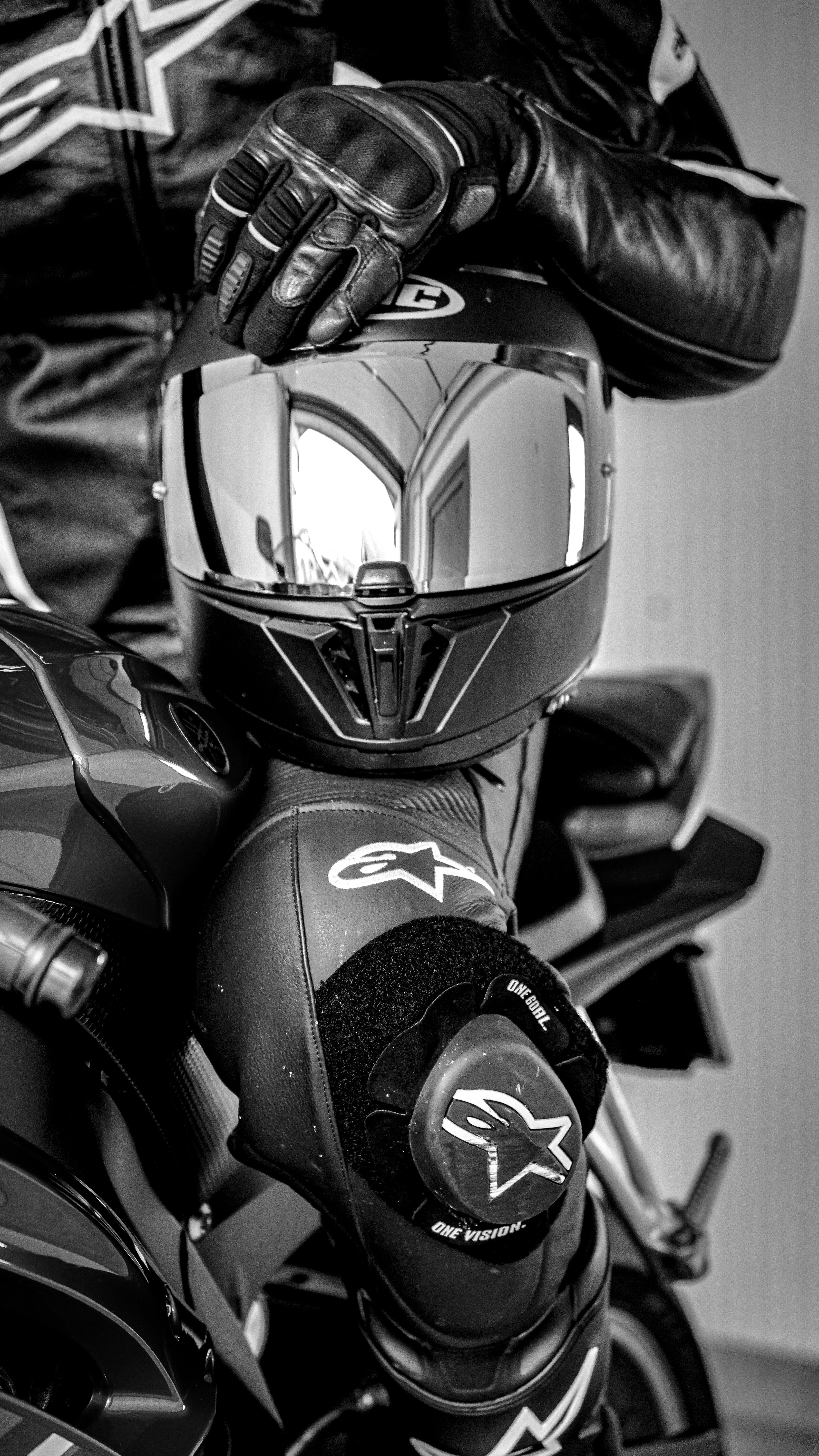 De franc Primer pla d'un motociclista amb roba de cuir negre i casc a la mà, que llueix un look de motorista clàssic i modern. Foto d'estoc