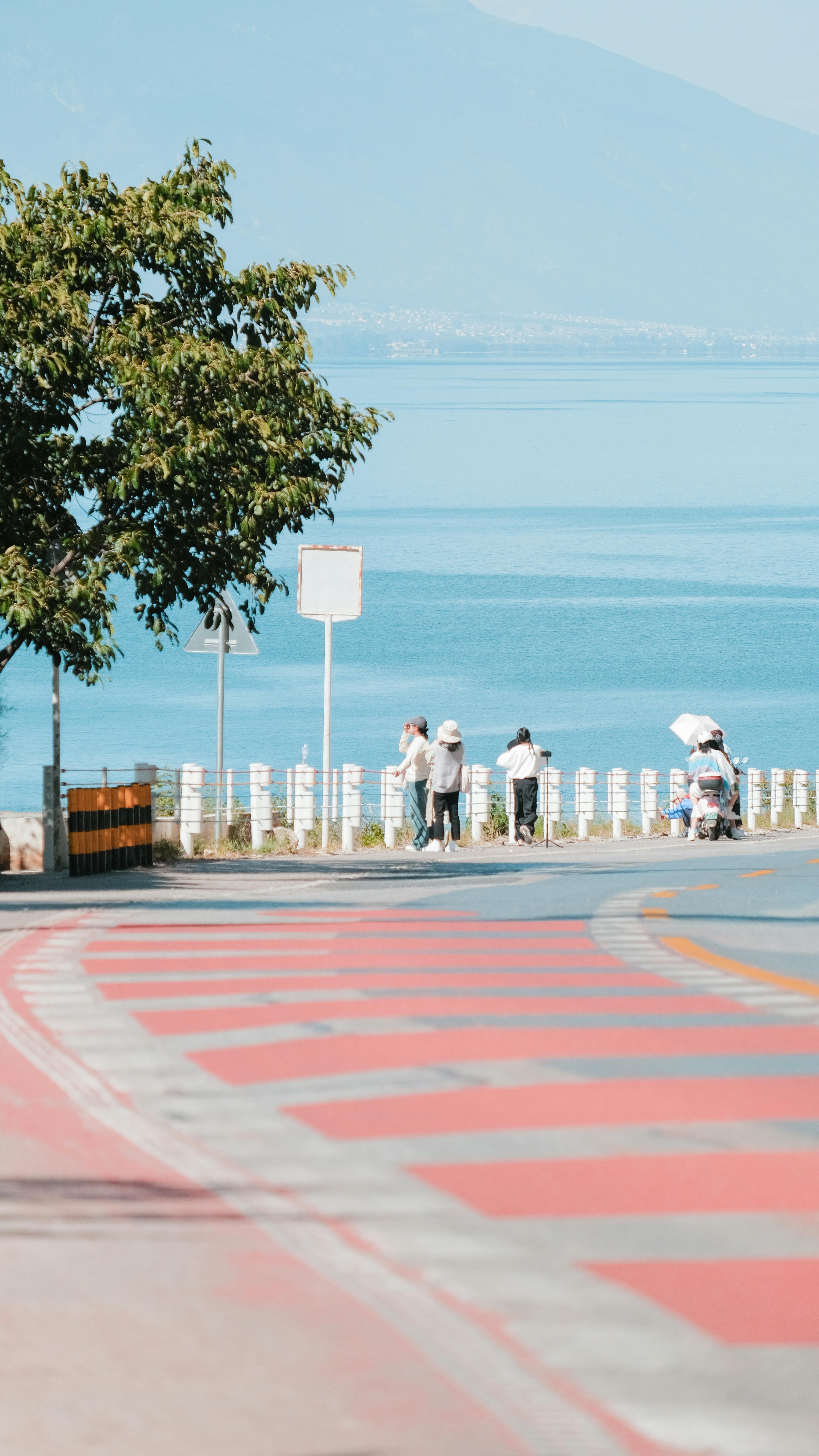 Free A peaceful scene depicting a lakeside path with people enjoying the view in Dali, China. Stock Photo