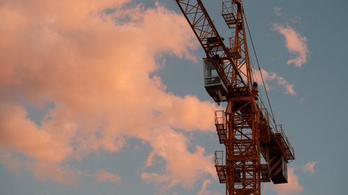 Free A construction crane silhouetted against a colorful sunset sky in Dali, showcasing industrial progress. Stock Photo