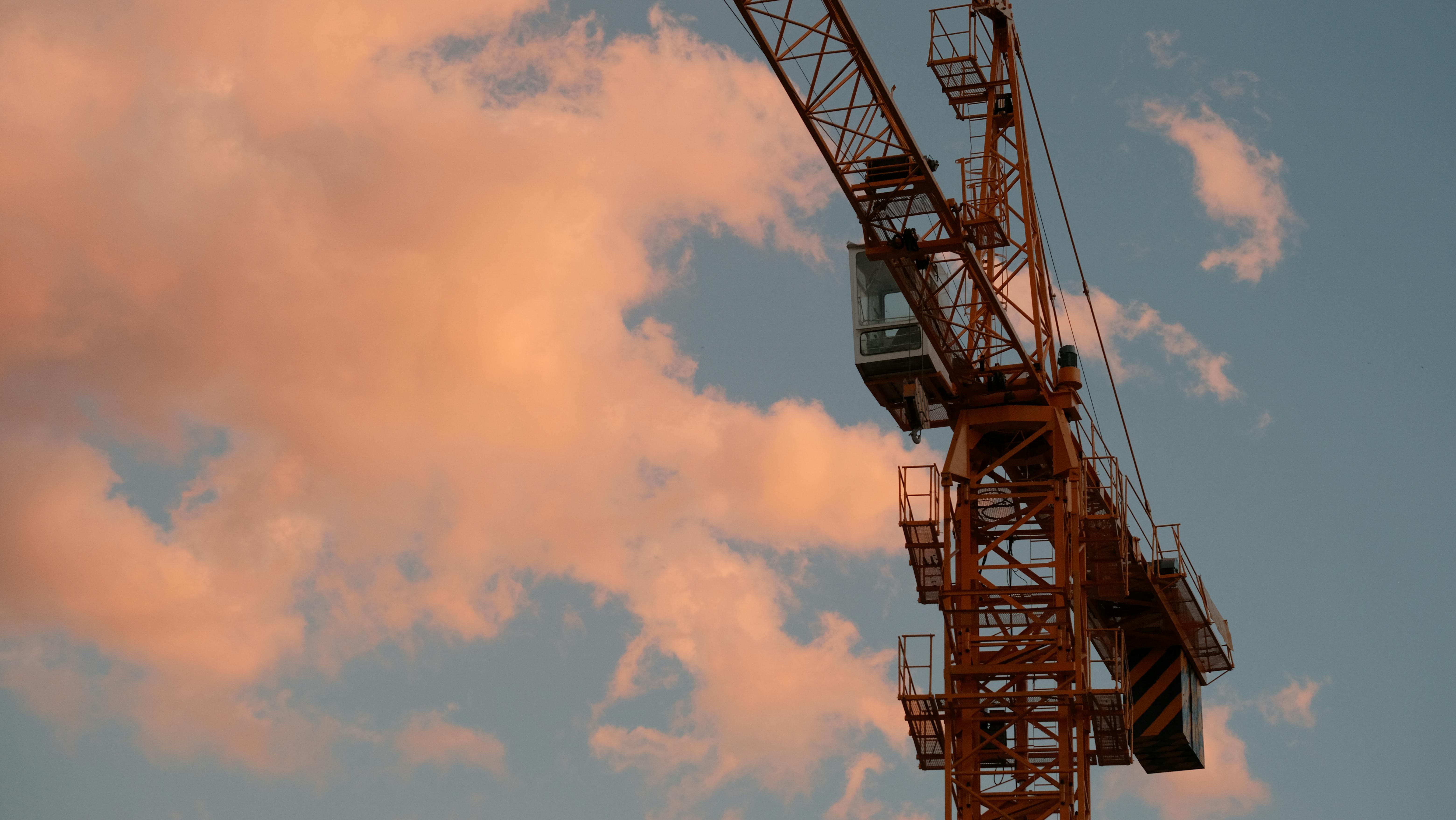 Ücretsiz Dali'de, renkli gün batımı gökyüzüne karşı silueti beliren bir inşaat vinci, endüstriyel ilerlemeyi sergiliyor. Stok Fotoğraflar