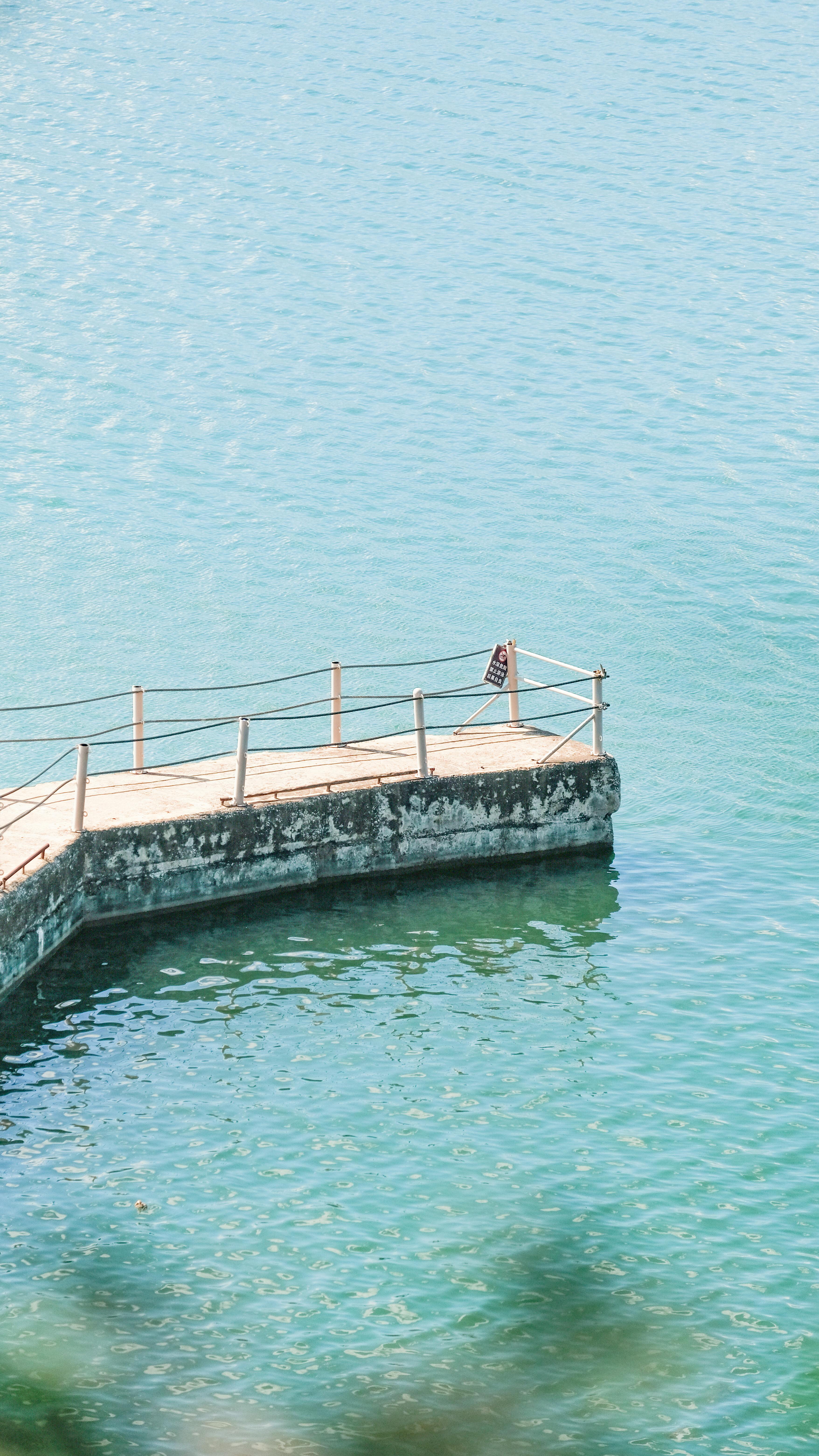De franc Un moll tranquil s'estén a les aigües blaves i cristal·lines de Dali, Xina, creant una escena serena a la vora del llac. Foto d'estoc