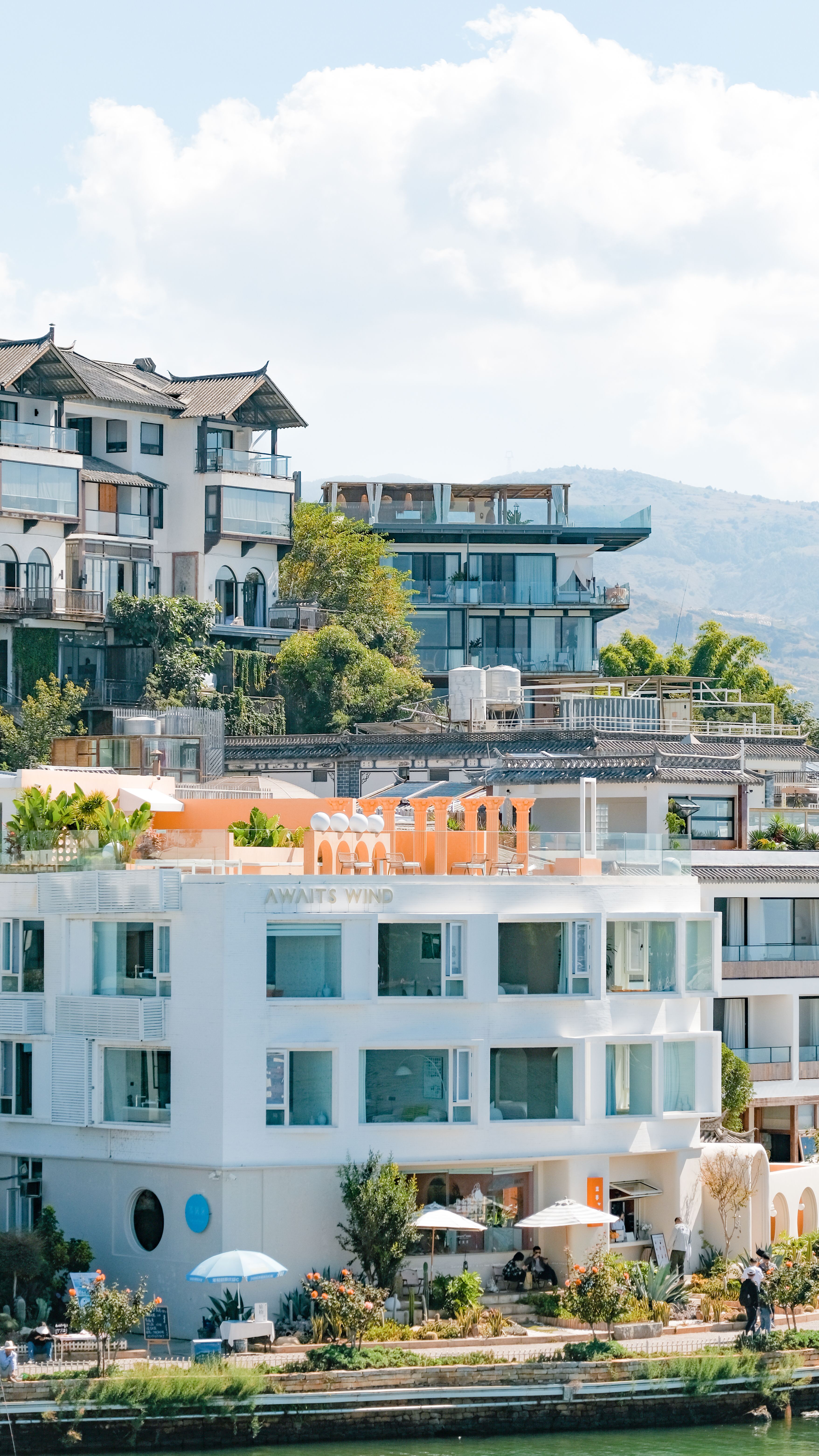Bright day view of modern architecture in Dali, China, with lush greenery.
