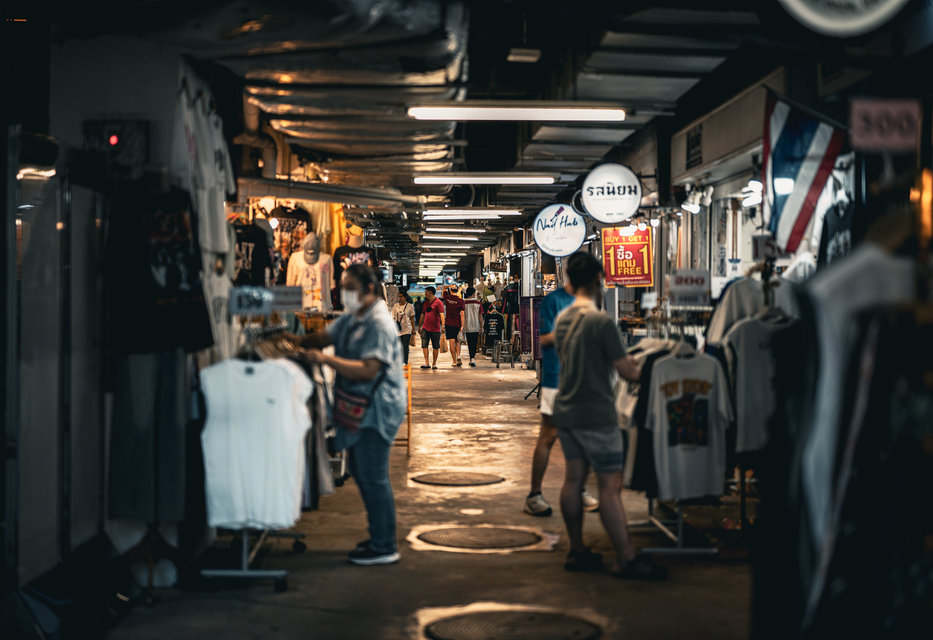 Crowded market lane in Bangkok with hanging lights