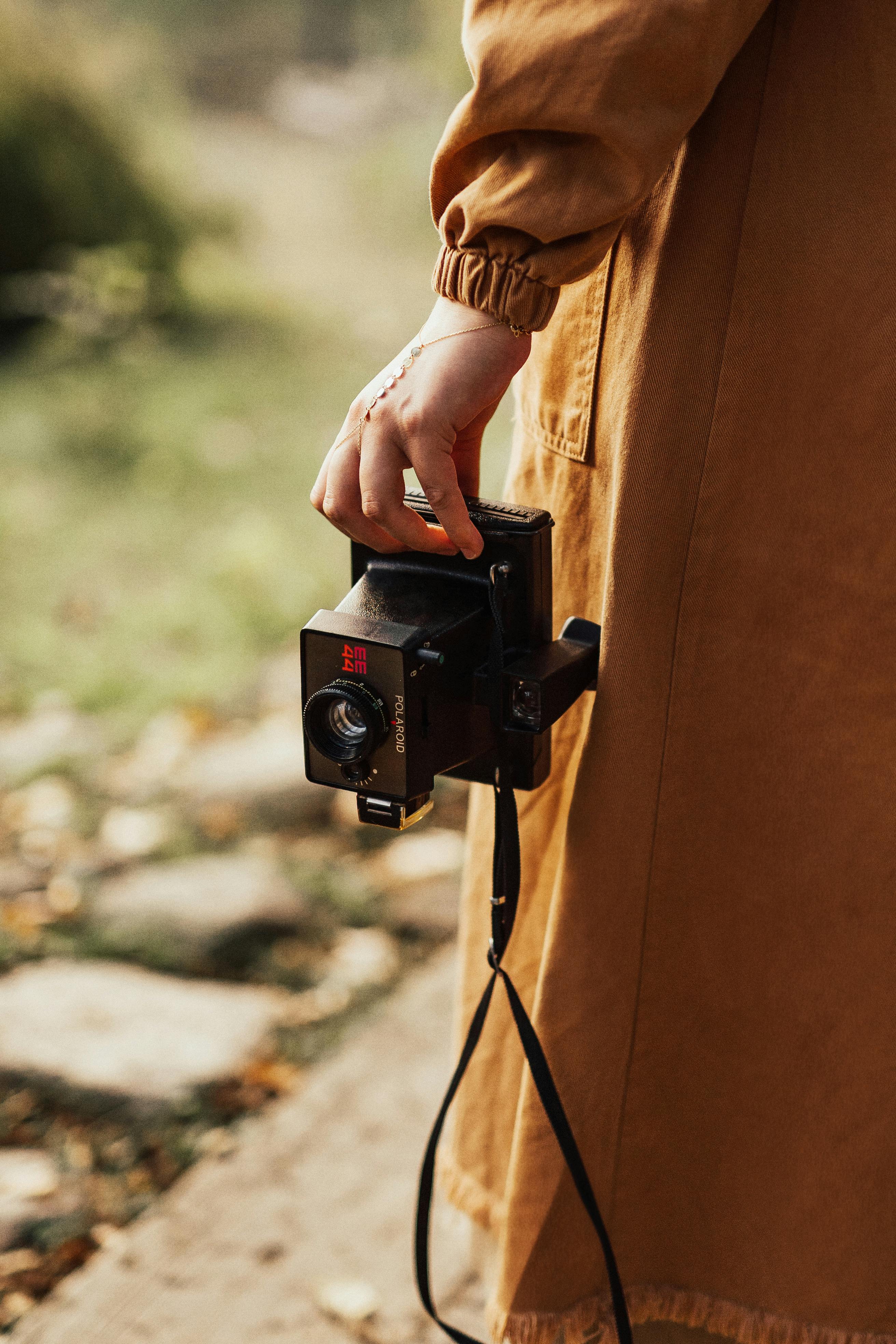 Gratuit Prim-plan al unei persoane care ține în mână un aparat foto Polaroid vintage în aer liber, toamna. Fotografie de stoc