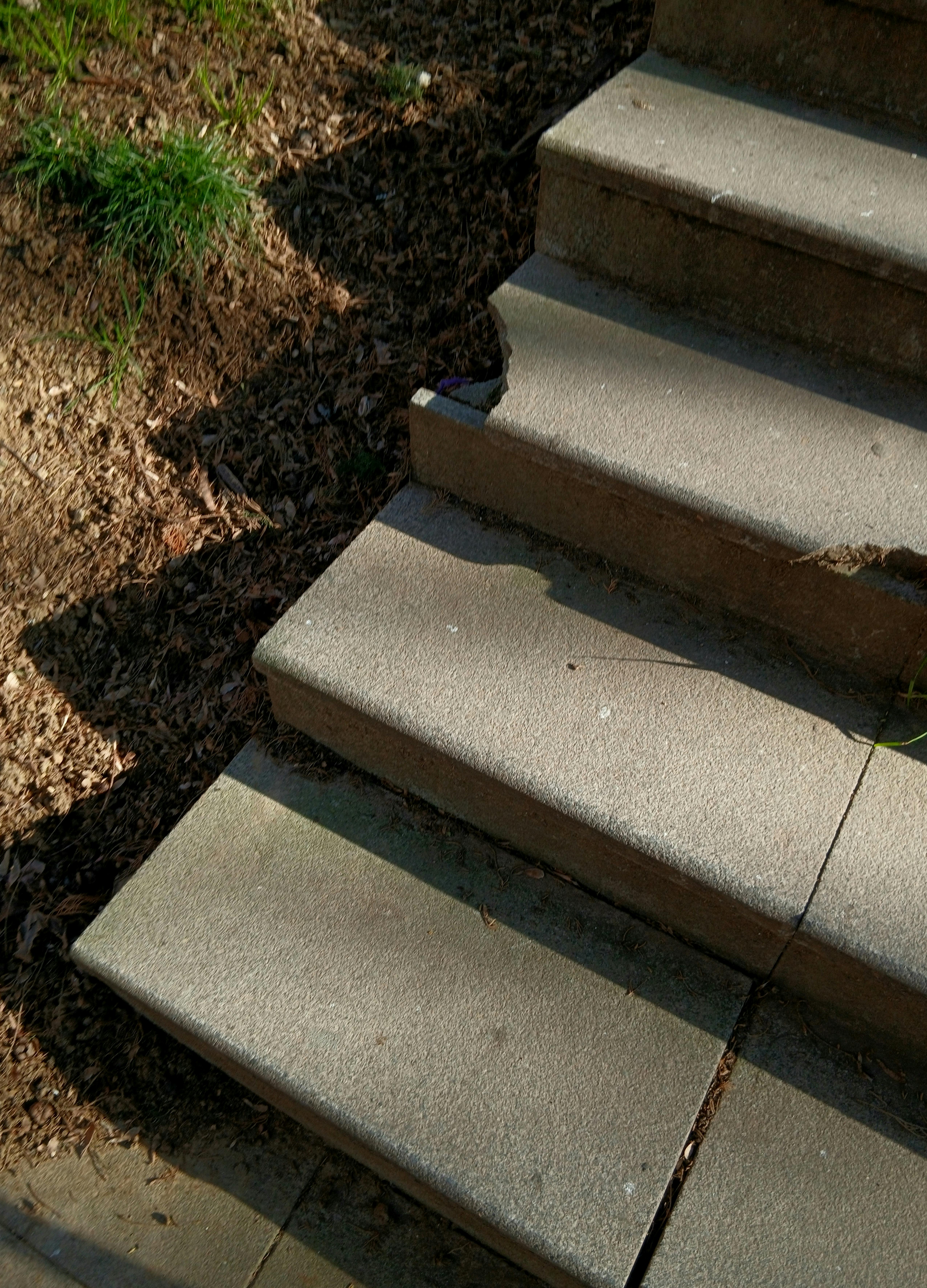 Kostenlos Betonstufen führen ins Freie, wo natürliche Schatten und Sonnenlicht aufeinandertreffen. Stock-Foto