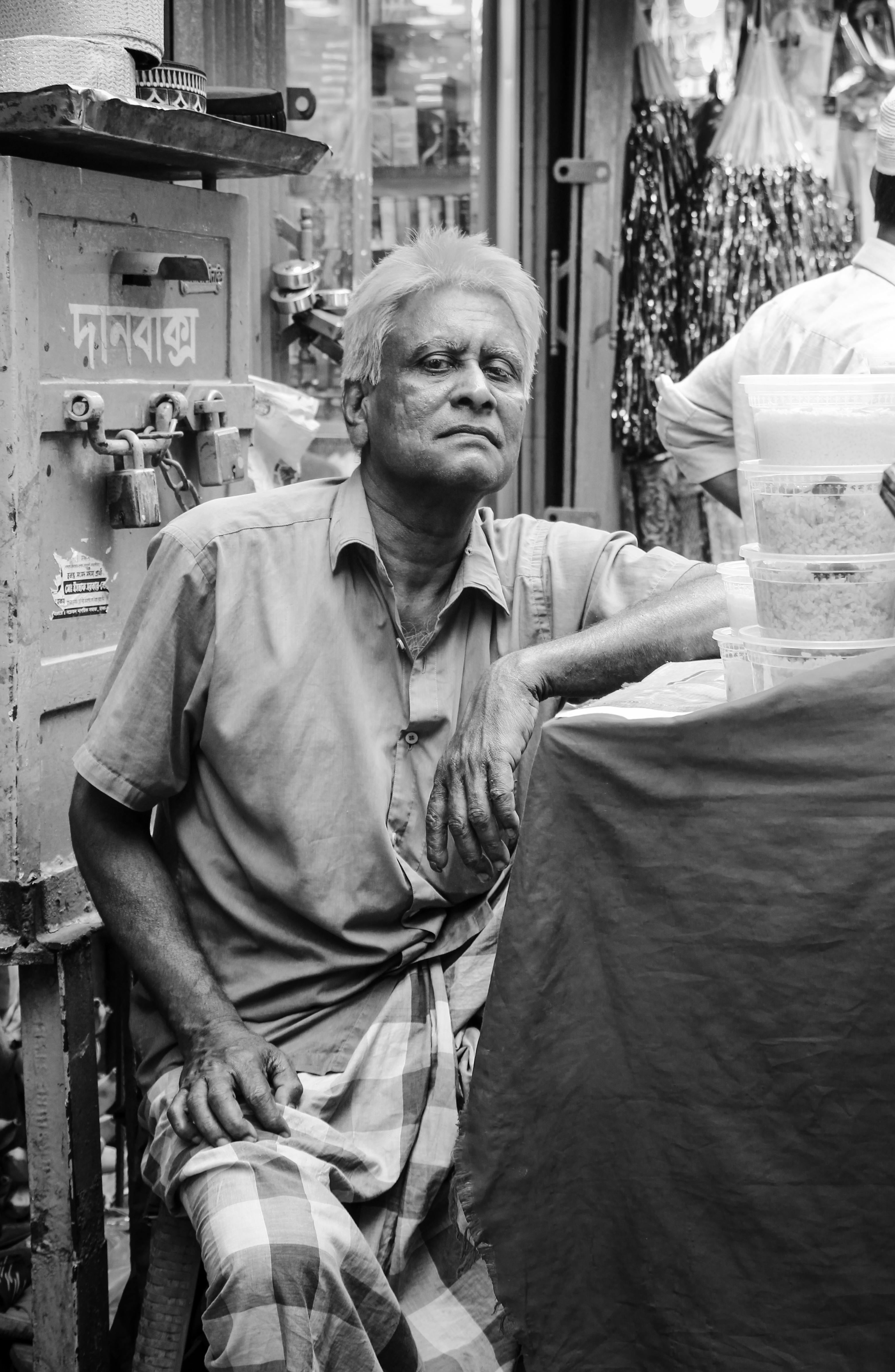 Ücretsiz Bangladeş'in Dakka şehrinde yaşlı bir sokak satıcısının özünü yansıtan siyah beyaz portre. Stok Fotoğraflar